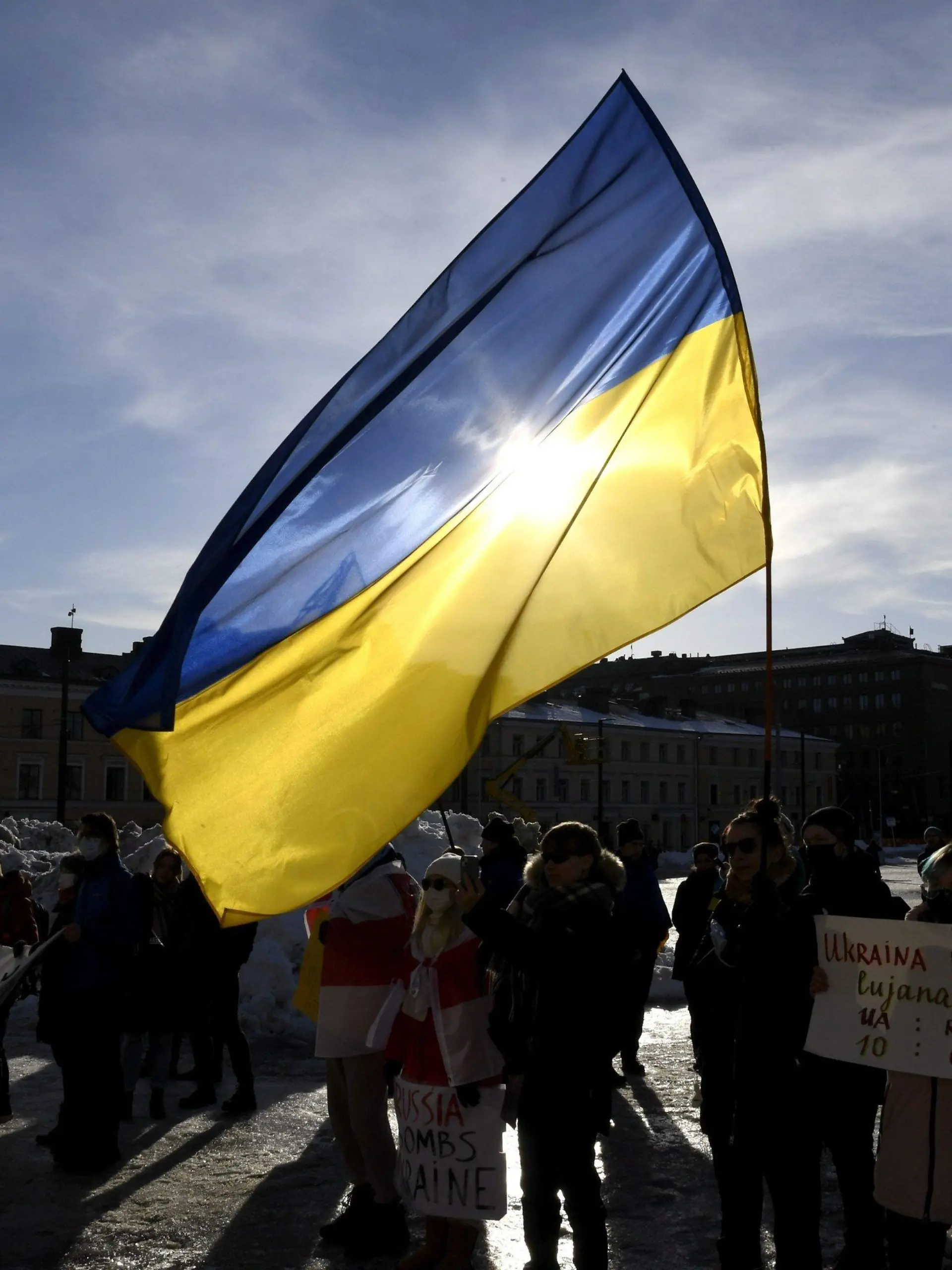 27.02.2022, Finnland, Helsinki: Teilnehmer einer Demonstration halten eine ukrainische Fahne bei einem Protest gegen die Invasion in die Ukraine. Russlands Nachbar Finnland will seine militärische Abwehr wegen der Entwicklungen in der Ukraine mit Waffensystemen aus Israel stärken. Foto: Jussi Nukari/Lehtikuva/dpa +++ dpa-Bildfunk +++