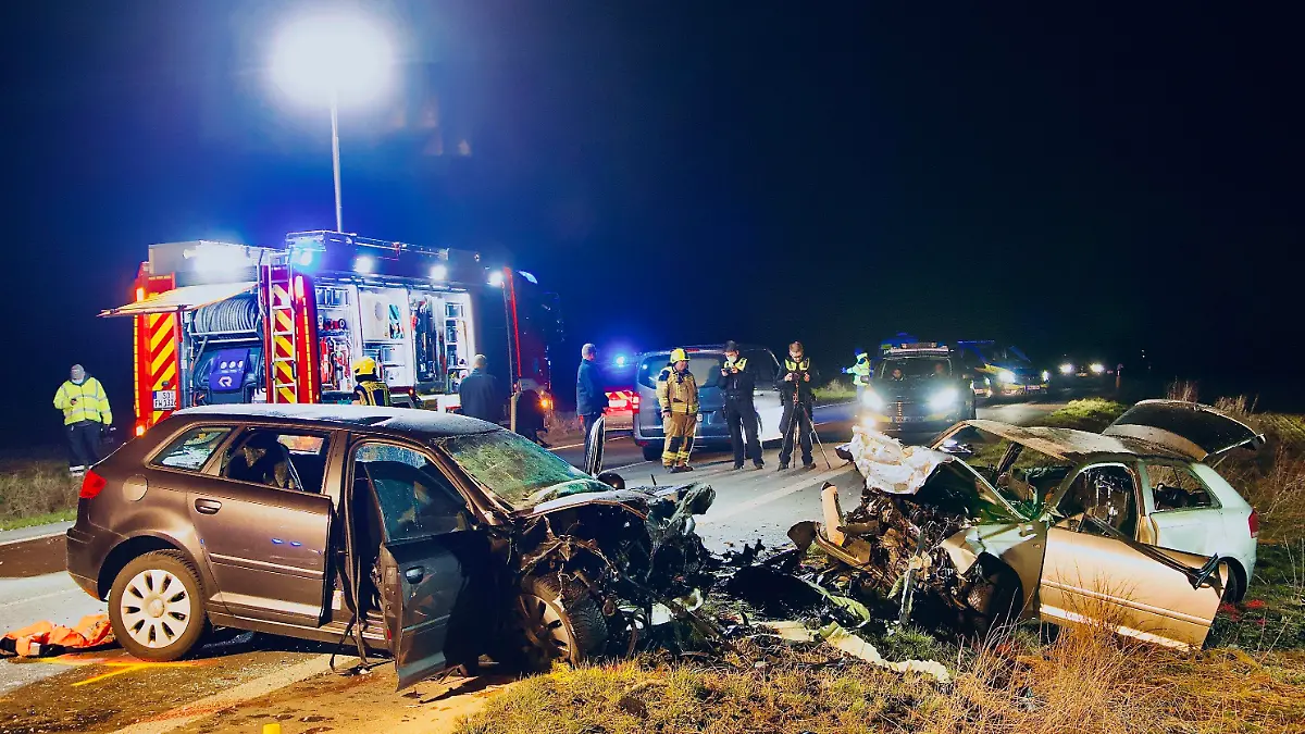 05.03.2022, Nordrhein-Westfalen, Unna: Einsatzkräfte der Polizei und Feuerwehr stehen an der Unfallstelle. Bei einem Frontalzusammenstoß in Unna sind am Samstag drei Menschen gestorben. Foto: Andreas Dunker/dpa +++ dpa-Bildfunk +++