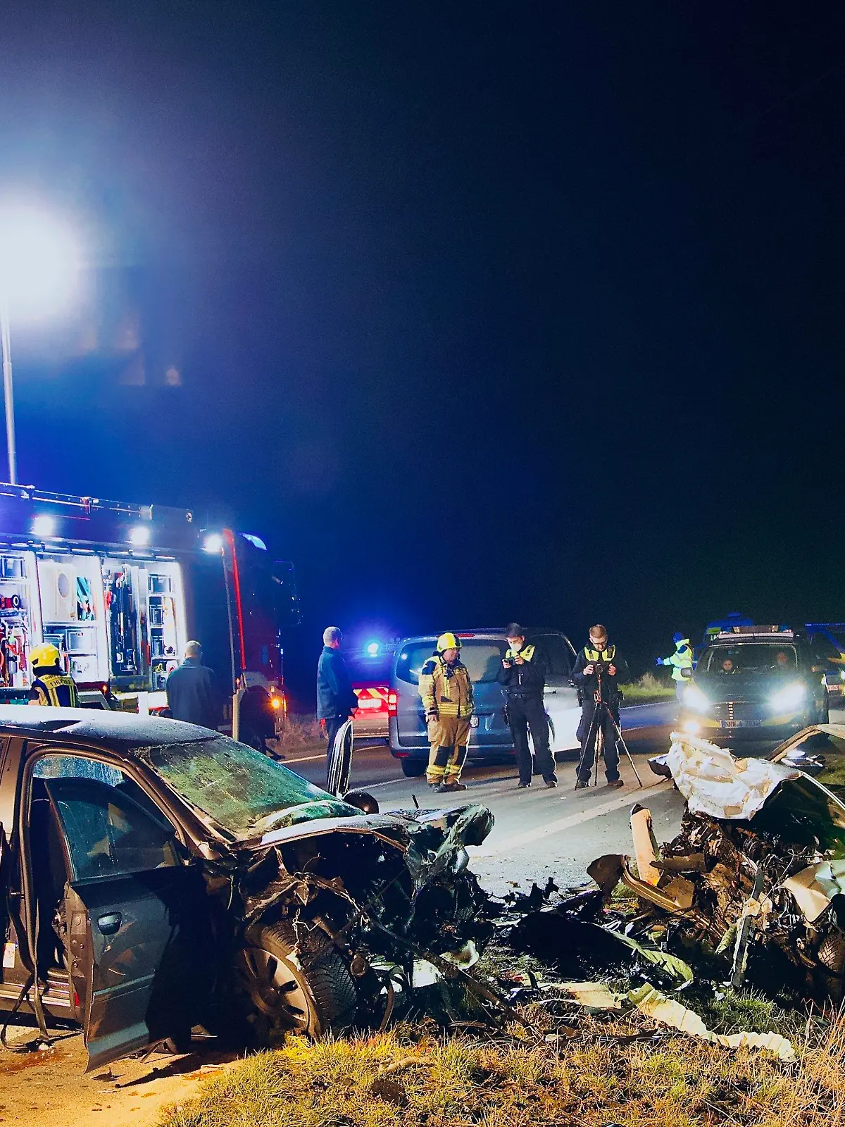 05.03.2022, Nordrhein-Westfalen, Unna: Einsatzkräfte der Polizei und Feuerwehr stehen an der Unfallstelle. Bei einem Frontalzusammenstoß in Unna sind am Samstag drei Menschen gestorben. Foto: Andreas Dunker/dpa +++ dpa-Bildfunk +++
