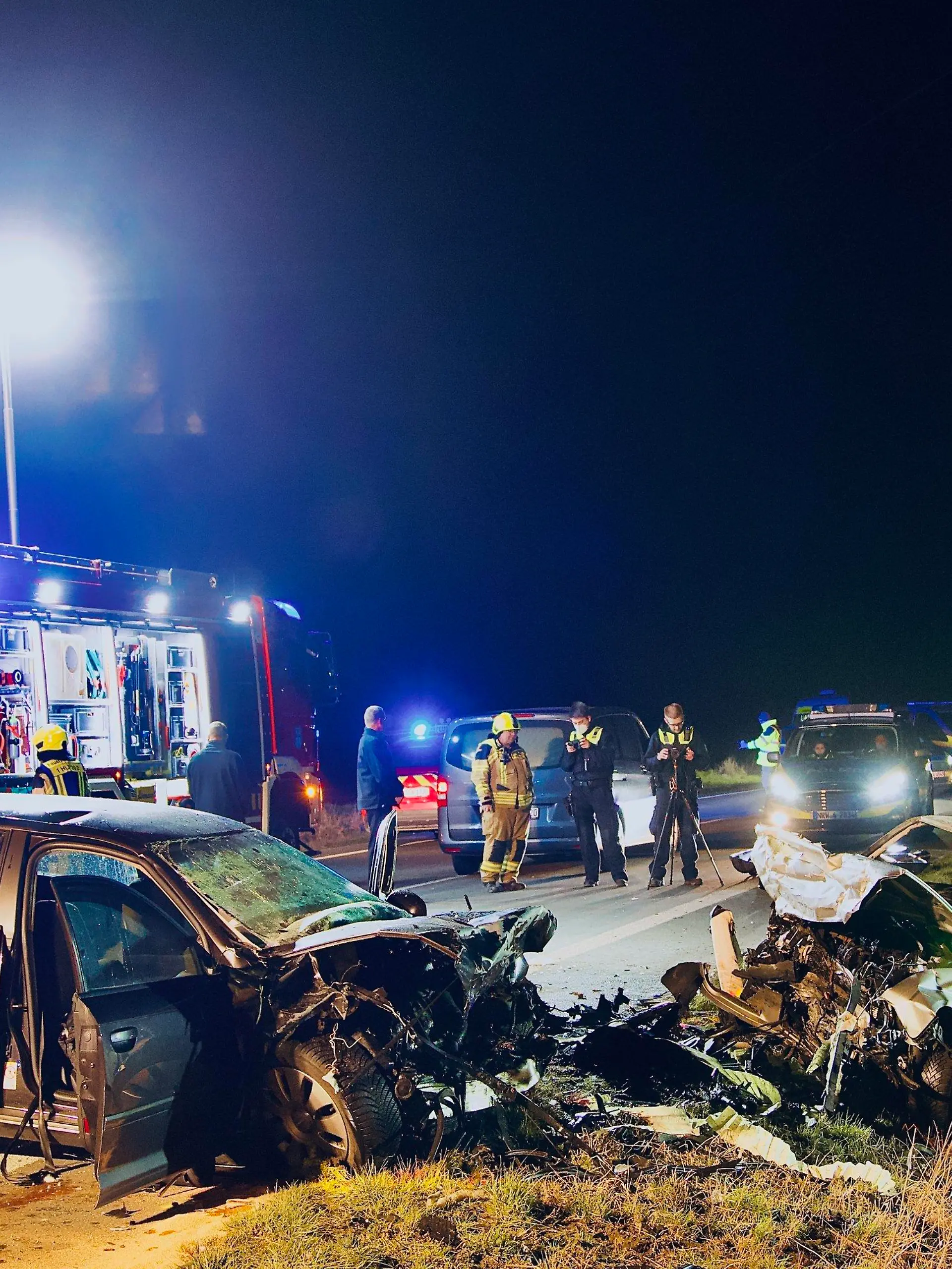 05.03.2022, Nordrhein-Westfalen, Unna: Einsatzkräfte der Polizei und Feuerwehr stehen an der Unfallstelle. Bei einem Frontalzusammenstoß in Unna sind am Samstag drei Menschen gestorben. Foto: Andreas Dunker/dpa +++ dpa-Bildfunk +++