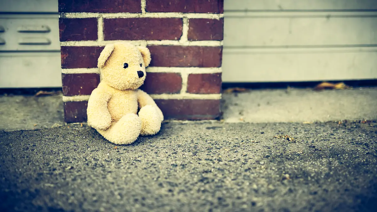 Teddy sitzt allein und traurig auf dem Boden, Symbolfoto Kindheitstrauma