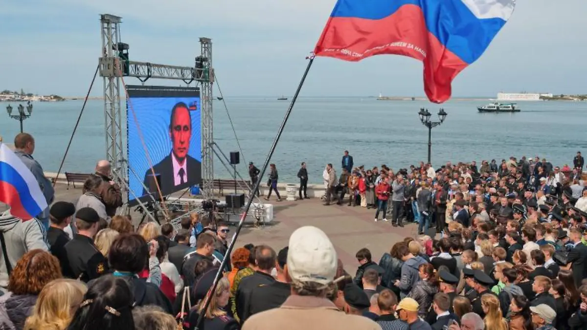 Menschen in Sewastopol bei einer Fernseh-Ansprache: Auf der Krim wird der fünfte Jahrestag der umstrittenen Vereinigung mit Russland gefeiert. Foto: Anton Pedko/EPA