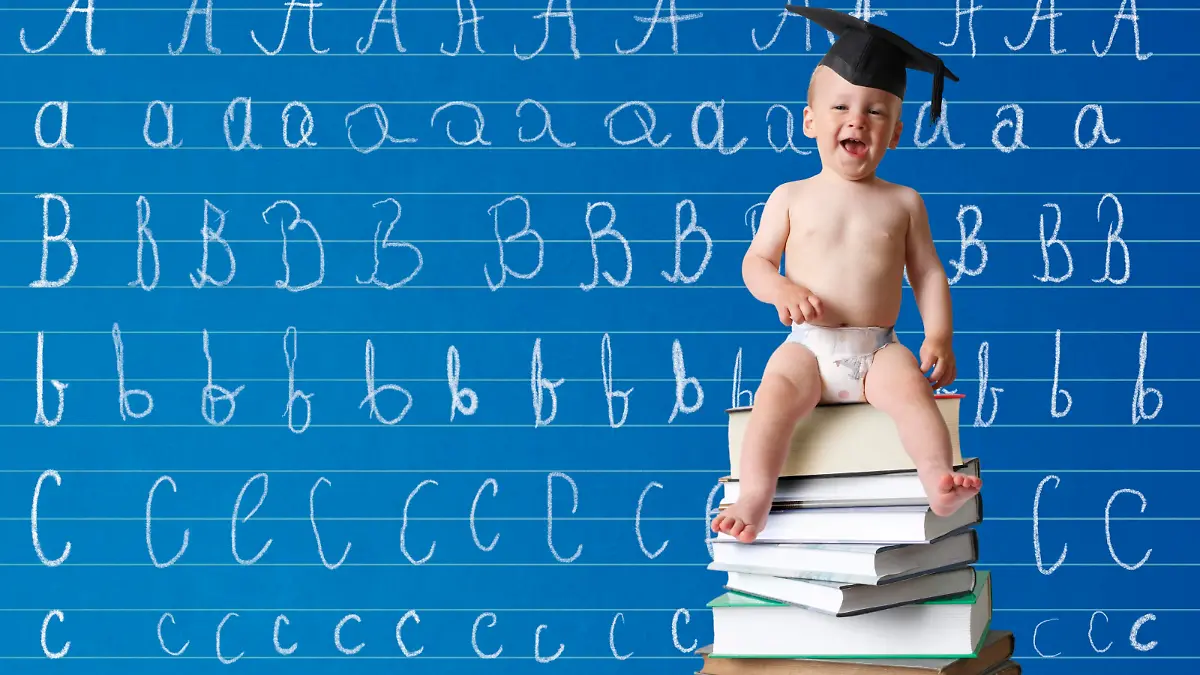 Kleinkind mit Doktorhut sitzt auf Bücherstapel vor Schultafel mit ABC || Modellfreigabe vorhanden
