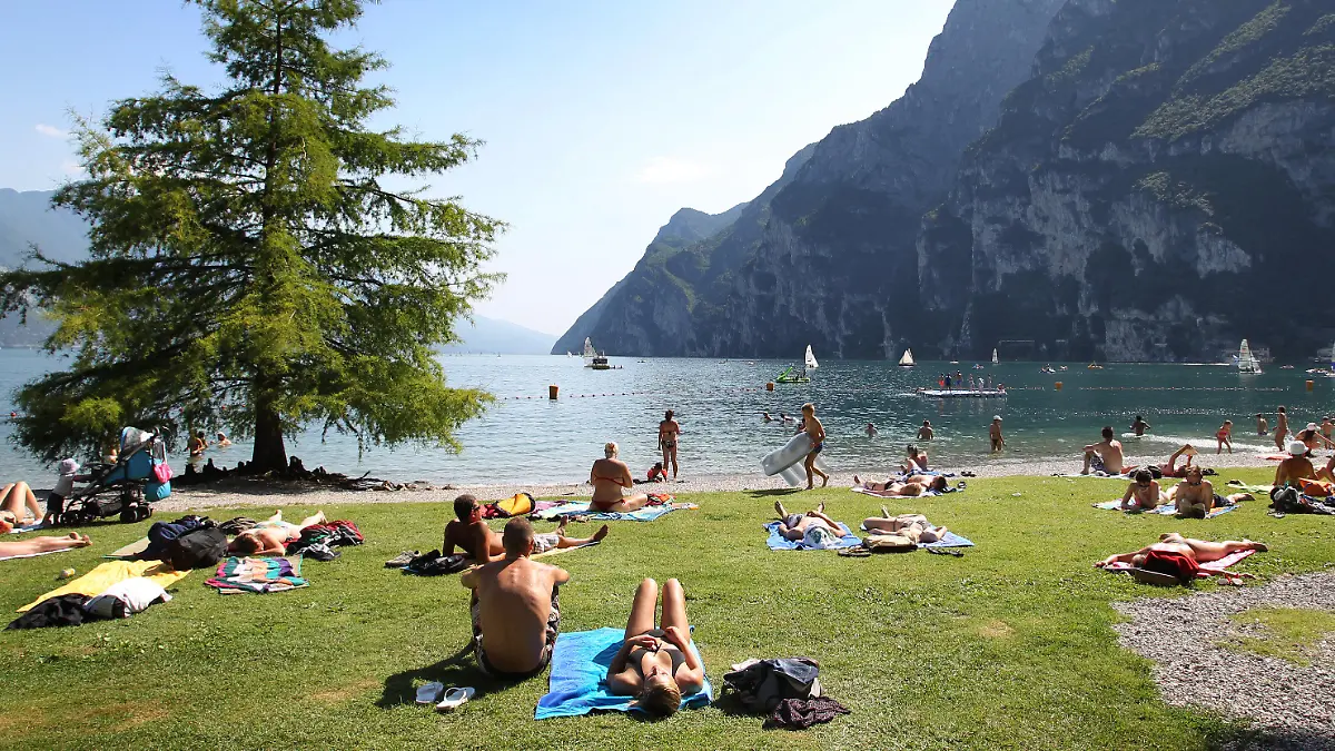 ARCHIV - 17.07.2012, Italien, Riva Del Garda: Touristen und Einheimische nehmen am Strand von Riva del Garda ein Sonnenbad. (zu dpa: "Gardasee wartet auf deutsche Touristen: Keine Masken am Strand") Foto: picture alliance / dpa +++ dpa-Bildfunk +++