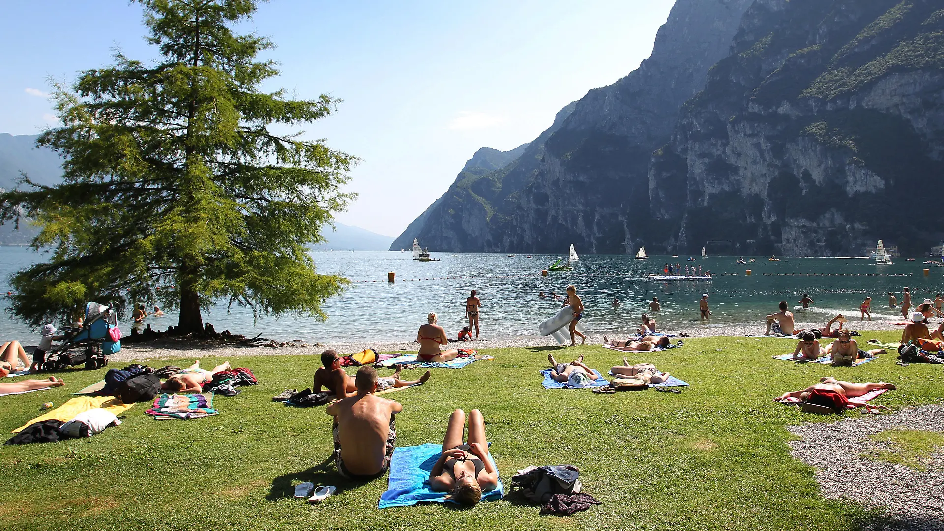 ARCHIV - 17.07.2012, Italien, Riva Del Garda: Touristen und Einheimische nehmen am Strand von Riva del Garda ein Sonnenbad. (zu dpa: "Gardasee wartet auf deutsche Touristen: Keine Masken am Strand") Foto: picture alliance / dpa +++ dpa-Bildfunk +++