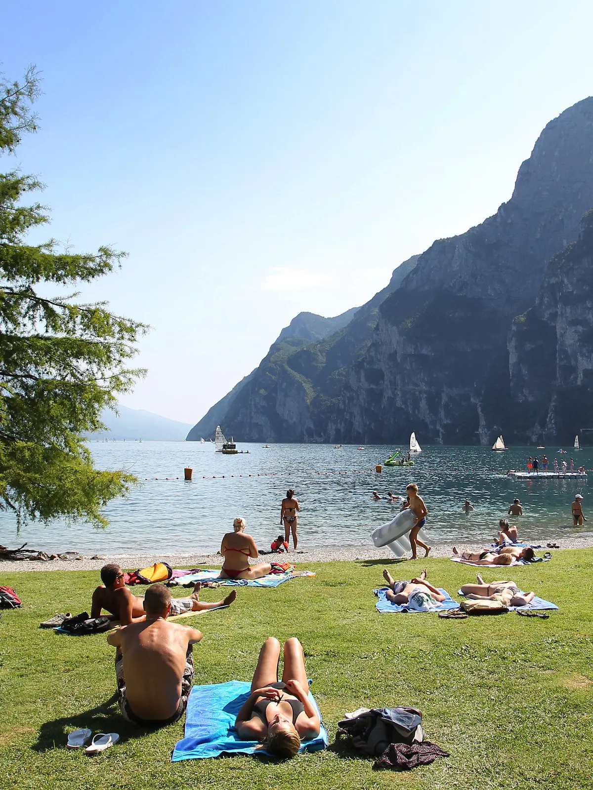ARCHIV - 17.07.2012, Italien, Riva Del Garda: Touristen und Einheimische nehmen am Strand von Riva del Garda ein Sonnenbad. (zu dpa: "Gardasee wartet auf deutsche Touristen: Keine Masken am Strand") Foto: picture alliance / dpa +++ dpa-Bildfunk +++