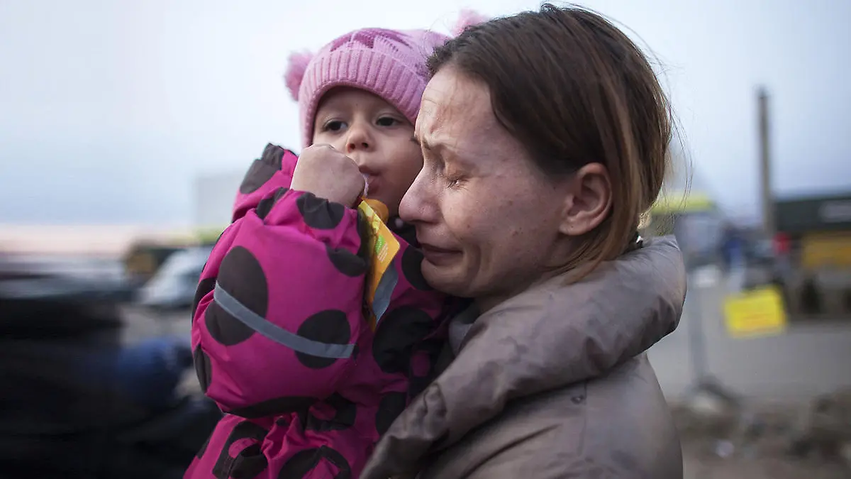 Ukrainische Mutter hält weinend ihr Kind auf dem Arm