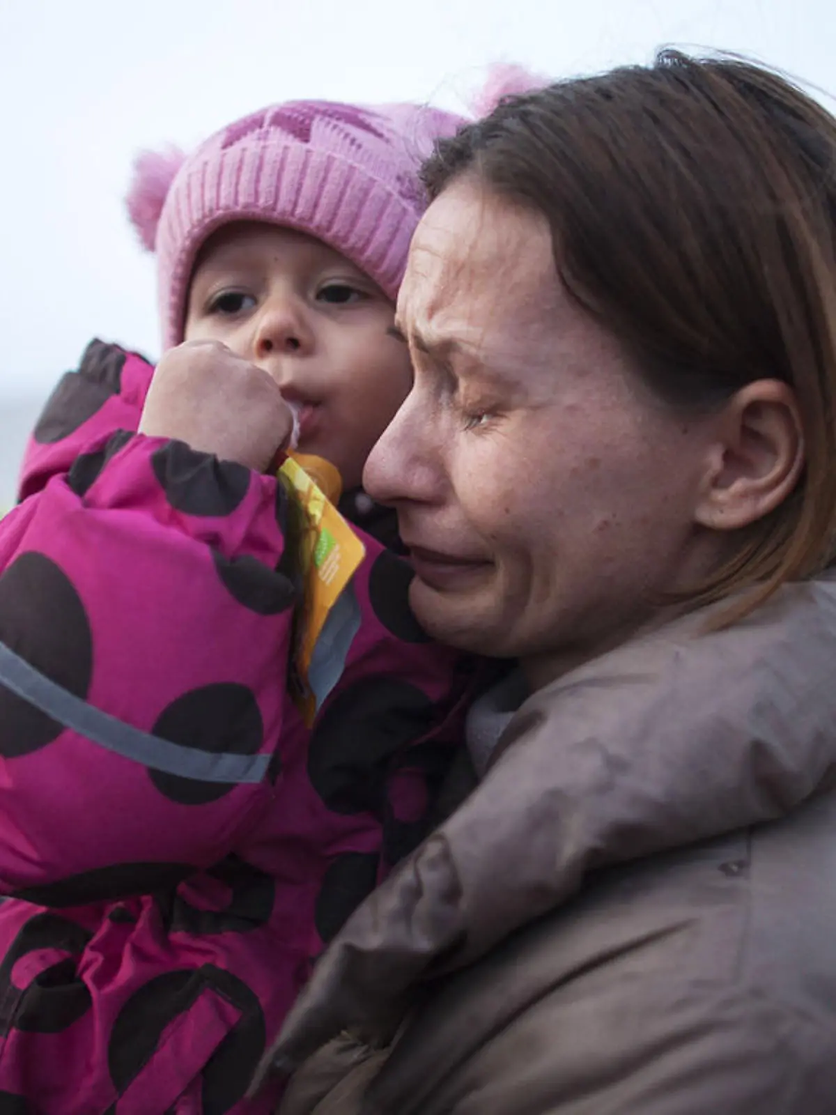 Ukrainische Mutter hält weinend ihr Kind auf dem Arm
