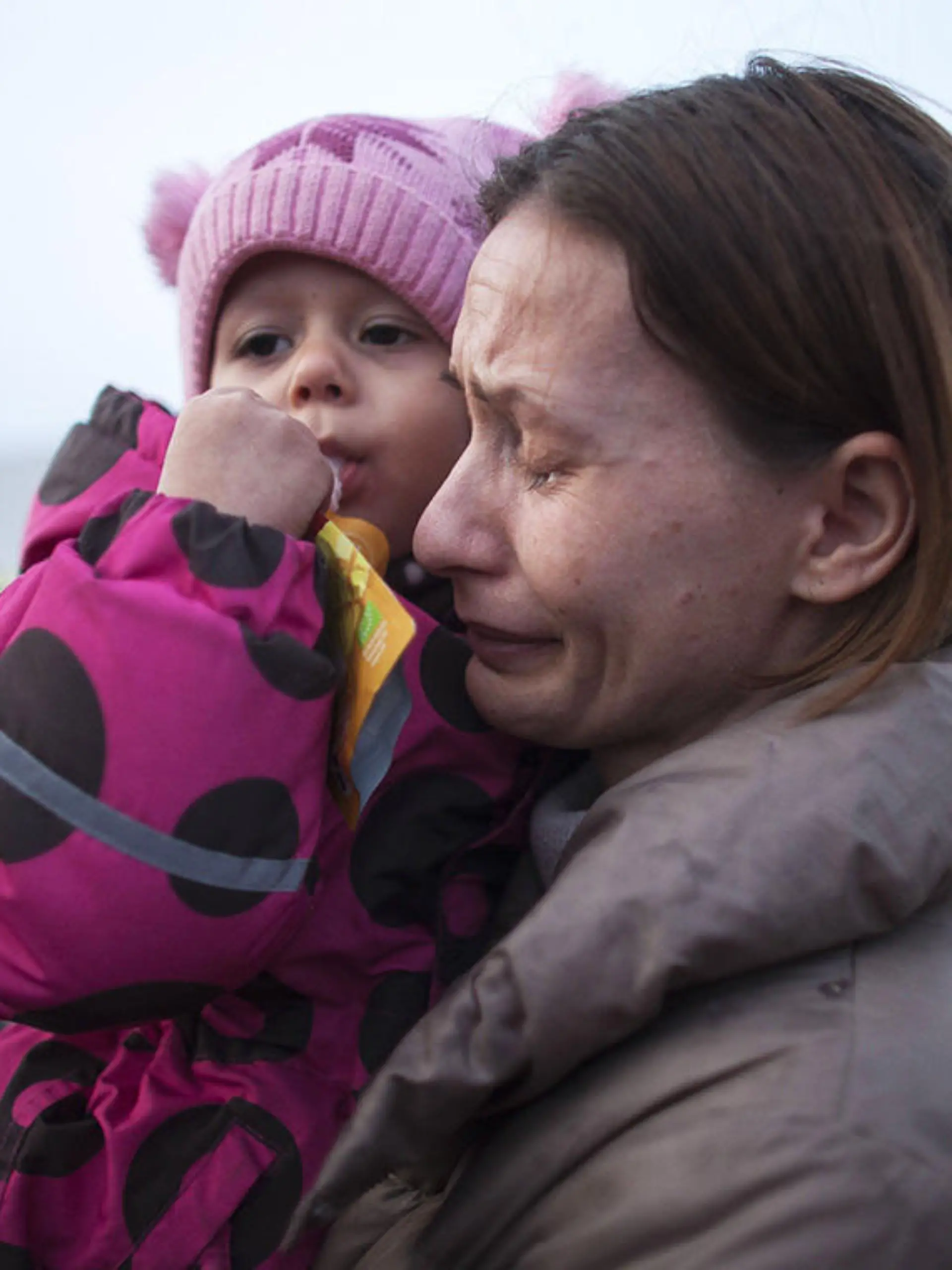 Ukrainische Mutter hält weinend ihr Kind auf dem Arm