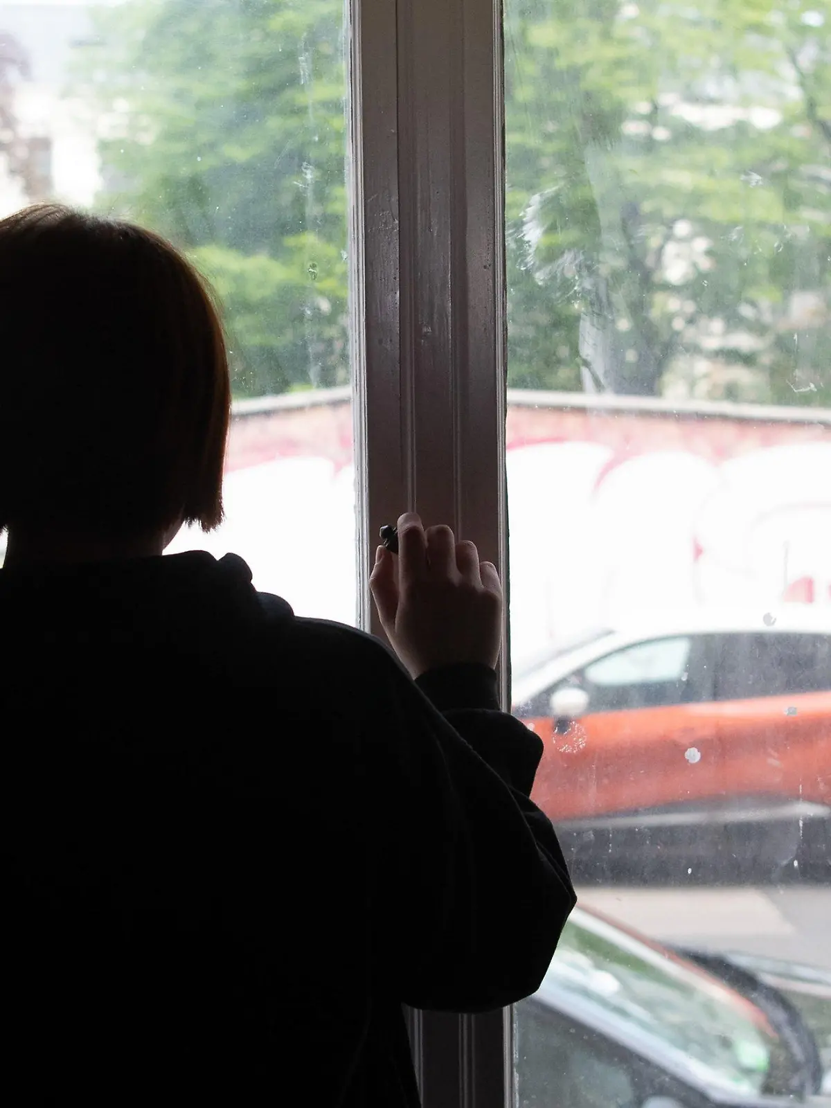 ARCHIV - 15.05.2021, Brandenburg, Potsdam: ILLUSTRATION - Eine Jugendliche blickt aus einem Fenster. Die Pandemie hat bei Kindern und Jugendlichen deutliche Spuren bei der psychischen und körperlichen Gesundheit hinterlassen. (zu dpa: «DAK: 2020 mehr ältere Jugendliche wegen Depressionen behandelt») Foto: Paul Zinken/dpa +++ dpa-Bildfunk +++
