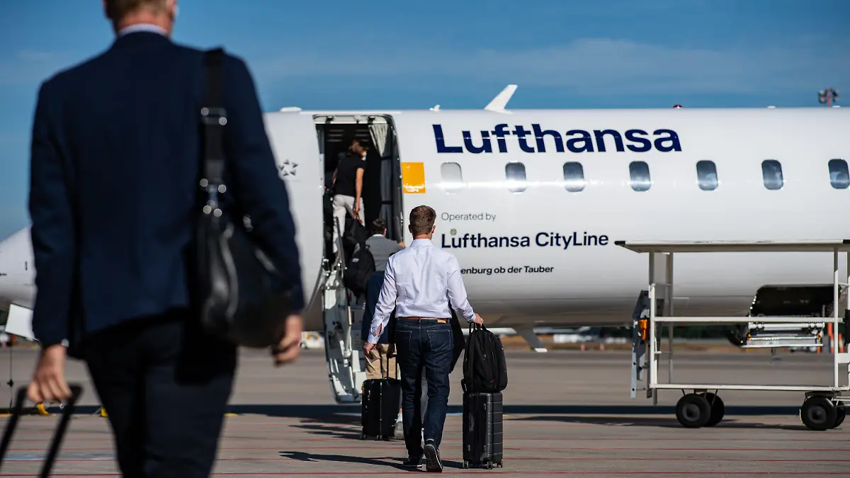 ARCHIV - 02.06.2020, Nordrhein-Westfalen, Münster: Passagiere gehen am Flughafen Münster-Osnabrück über das Rollfeld zu einer Lufthansa-Maschine. (Zu dpa "Lufthansa will Corona-Schnelltests für Passagiere anbieten") Foto: Guido Kirchner/dpa +++ dpa-Bildfunk +++