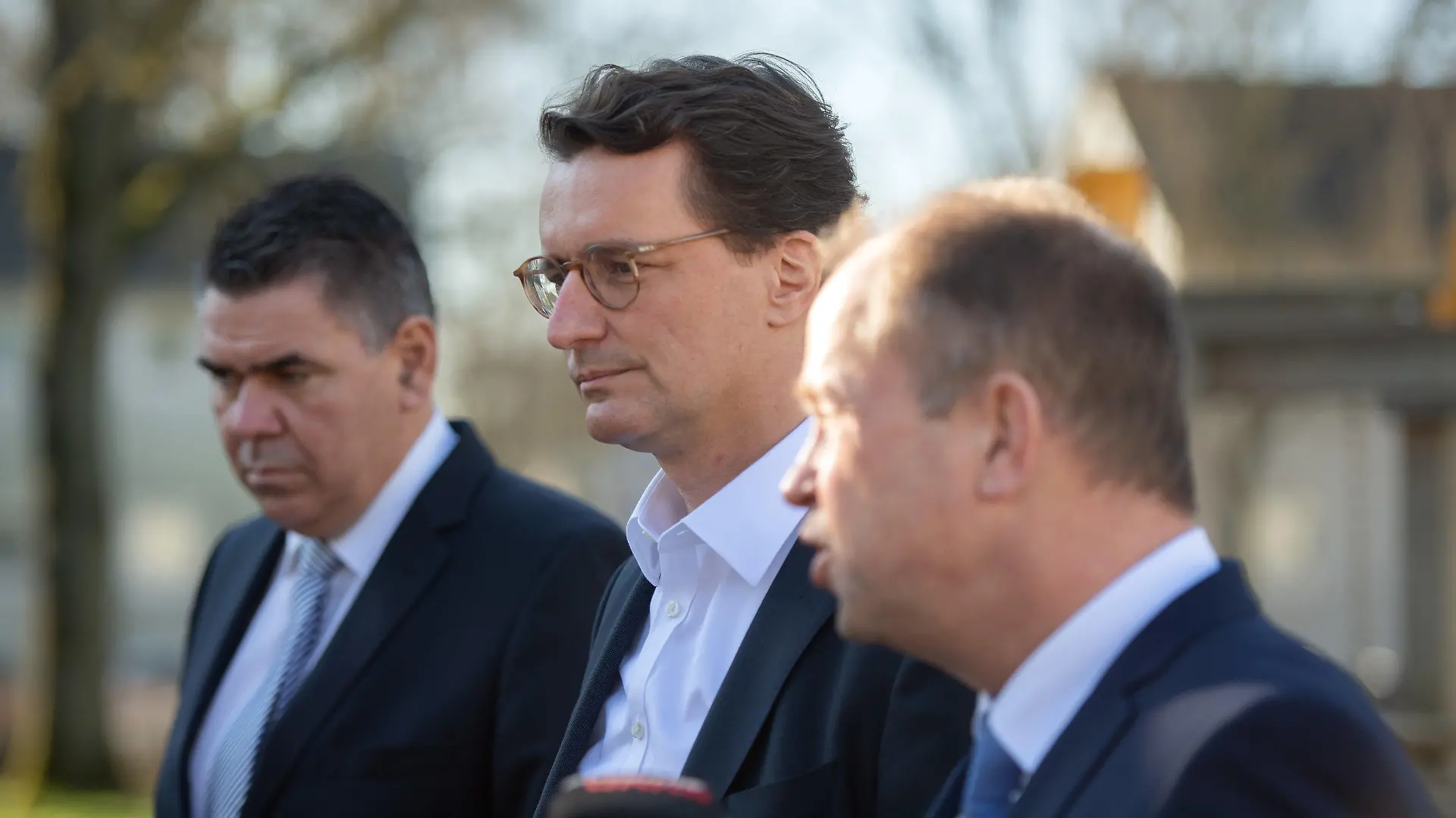 03.03.2022, Nordrhein-Westfalen, Unna: Mario Löhr (SPD, l), Landrat des Kreises Unna,, Hendrik Wüst, Ministerpräsident von Nordrhein-Westfalen (CDU, M) und Joachim Stamp, Minister für Flüchtlinge und Integration (FDP) geben in der Landesstelle Unna-Massen Pressestatements ab. Wüst wollte sich vor Ort über die Situation für Kriegsflüchtige aus der Ukraine informieren. Im Kreis Unna sind in den vergangenen Tagen erste geflüchtete Menschen aus der Ukraine angekommen, weitere werden erwartet. Foto: Bernd Thissen/dpa +++ dpa-Bildfunk +++