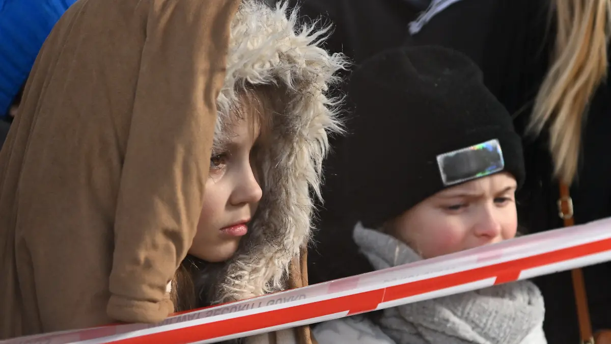 27.02.2022, Polen, Przemysl: Flüchtlingskinder aus der Ukraine stehen nach ihrer Ankunft am Bahnhof in Przemysl hinter einem Absperrband. Wegen des russischen Angriffs auf die Ukraine sind nach Angaben des UN-Flüchtlingshilfswerks (UNHCR) etwa 368 000 Menschen auf der Flucht. Foto: Darek Delmanowicz/PAP/dpa +++ dpa-Bildfunk +++