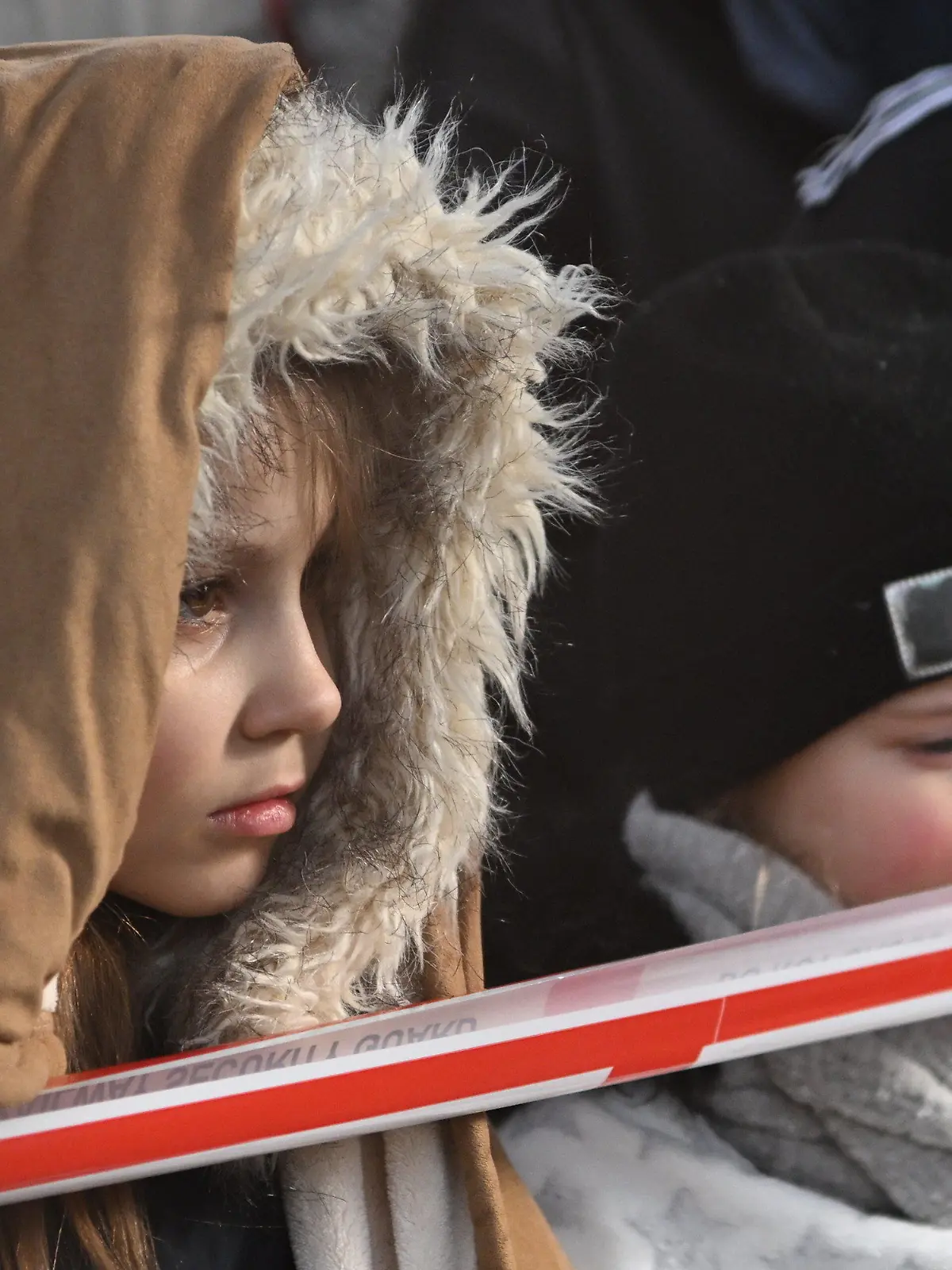 27.02.2022, Polen, Przemysl: Flüchtlingskinder aus der Ukraine stehen nach ihrer Ankunft am Bahnhof in Przemysl hinter einem Absperrband. Wegen des russischen Angriffs auf die Ukraine sind nach Angaben des UN-Flüchtlingshilfswerks (UNHCR) etwa 368 000 Menschen auf der Flucht. Foto: Darek Delmanowicz/PAP/dpa +++ dpa-Bildfunk +++