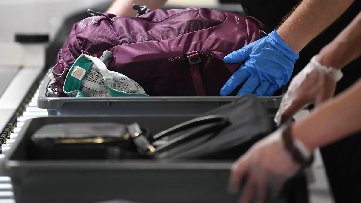 ARCHIV - 24.07.2019, Hessen, Frankfurt/Main: Das Handgepäck von Flugreisenden wird in einer Halle im Terminal 1 des Frankfurter Flughafens an der Passagierkontrolle in Plastikwannen abgelegt. Bei überlangen Wartezeiten an Flughafen- Sicherheitskontrollen haben Passagiere unter Umständen Anspruch auf Schadenersatz durch die Bundesrepublik. (zu dpa «Urteil: Bund haftet bei überlanger Wartezeit am Flughafen») Foto: Arne Dedert/dpa +++ dpa-Bildfunk +++