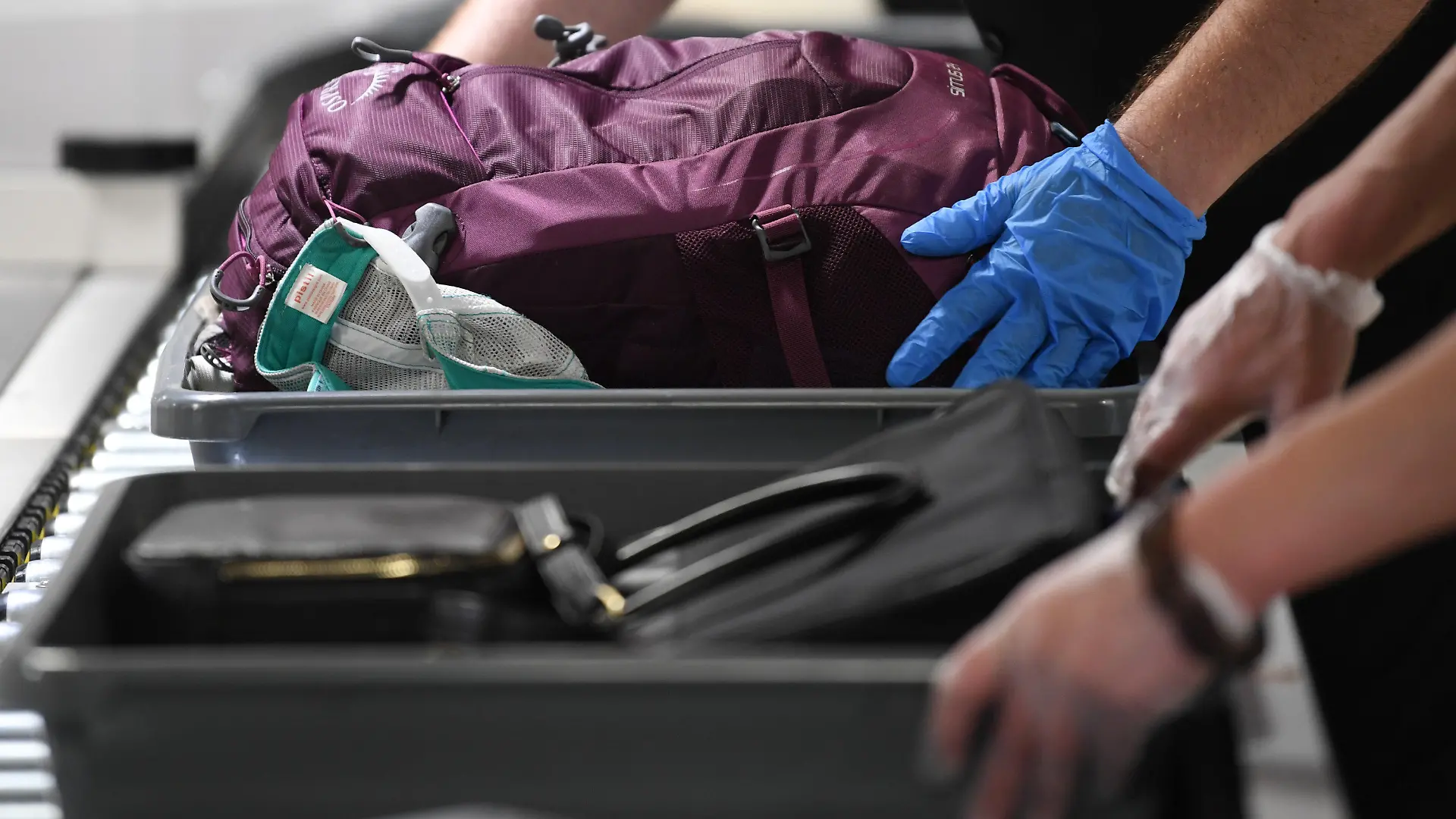 ARCHIV - 24.07.2019, Hessen, Frankfurt/Main: Das Handgepäck von Flugreisenden wird in einer Halle im Terminal 1 des Frankfurter Flughafens an der Passagierkontrolle in Plastikwannen abgelegt. Bei überlangen Wartezeiten an Flughafen- Sicherheitskontrollen haben Passagiere unter Umständen Anspruch auf Schadenersatz durch die Bundesrepublik. (zu dpa «Urteil: Bund haftet bei überlanger Wartezeit am Flughafen») Foto: Arne Dedert/dpa +++ dpa-Bildfunk +++