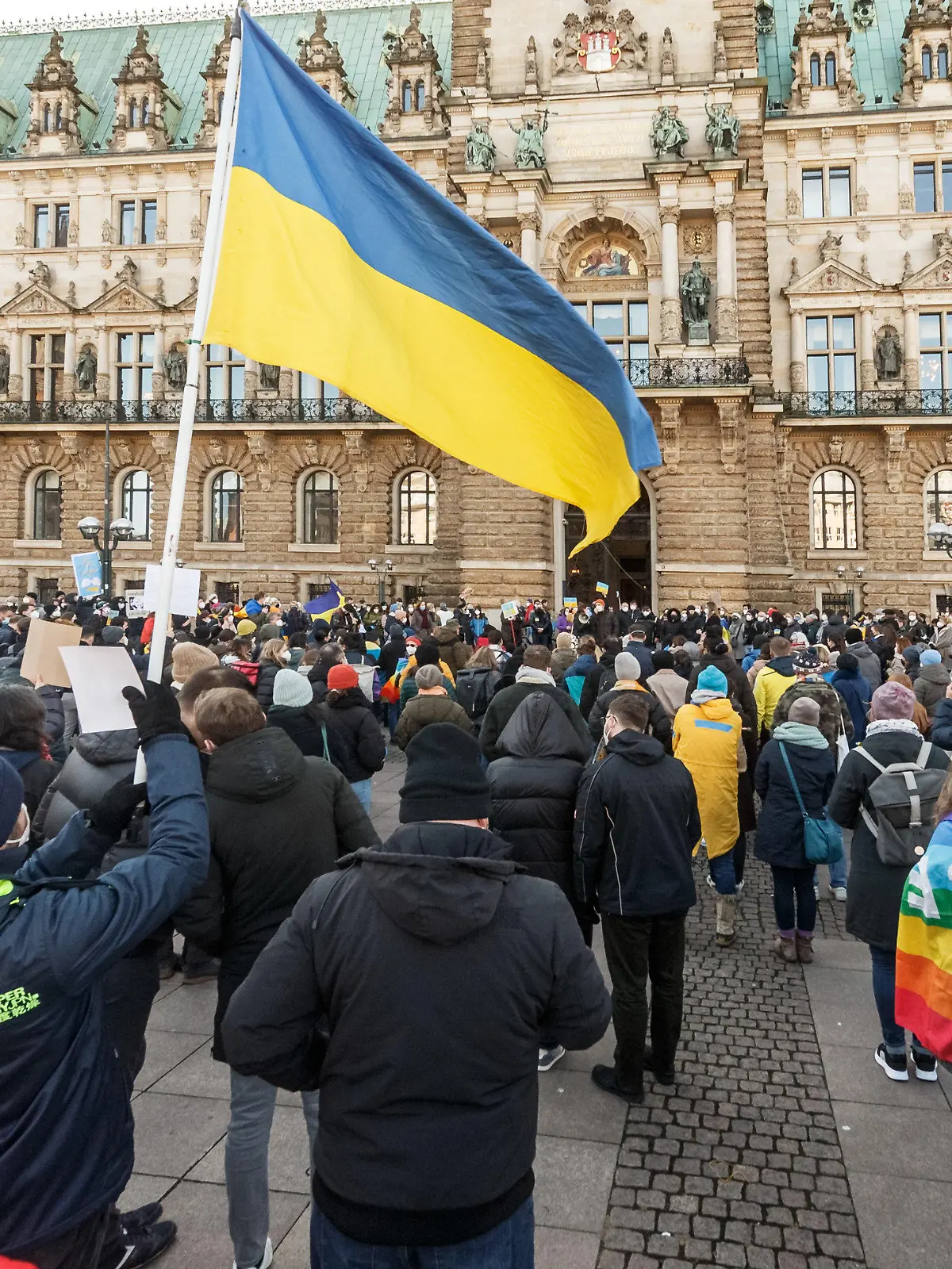 27.02.2022, Hamburg: Ein Kundgebungsteilnehmer hält eine ukrainische Fahne bei einer Demonstration auf dem Rathausmarkt gegen den russischen Angriff auf die Ukraine. Foto: Markus Scholz/dpa +++ dpa-Bildfunk +++