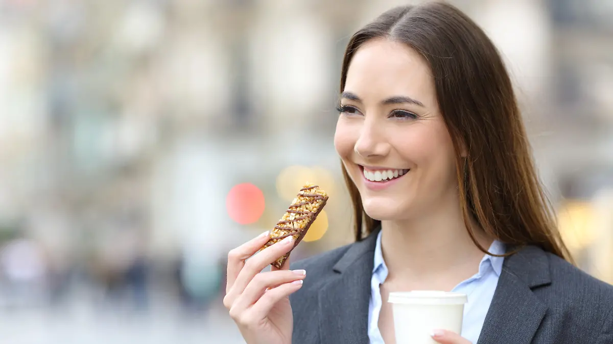 Happy executive holding coffee and bar in the street