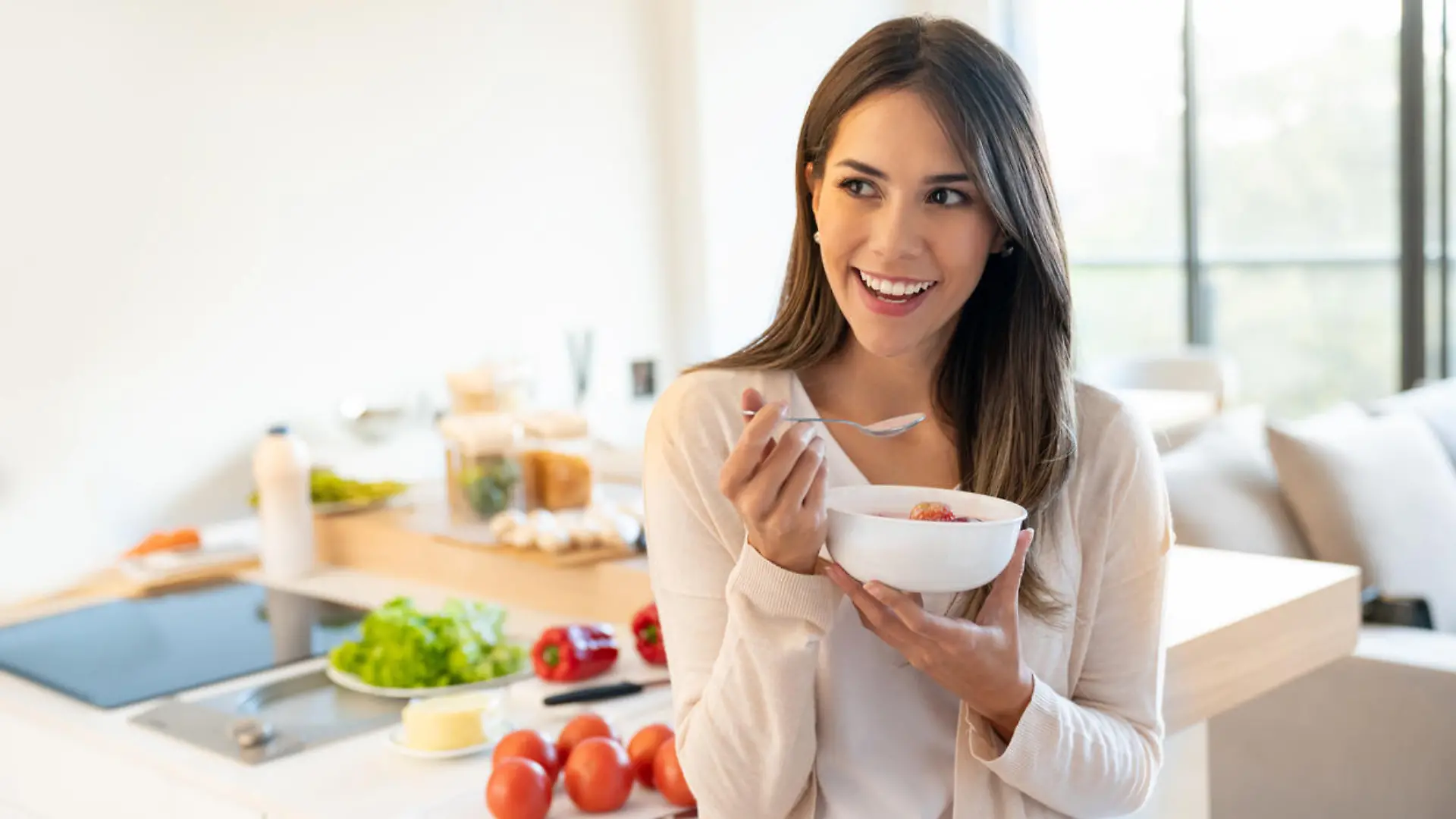 Portrait of a casual woman at home eating a healthy breakfast and looking happy - lifestyle concepts