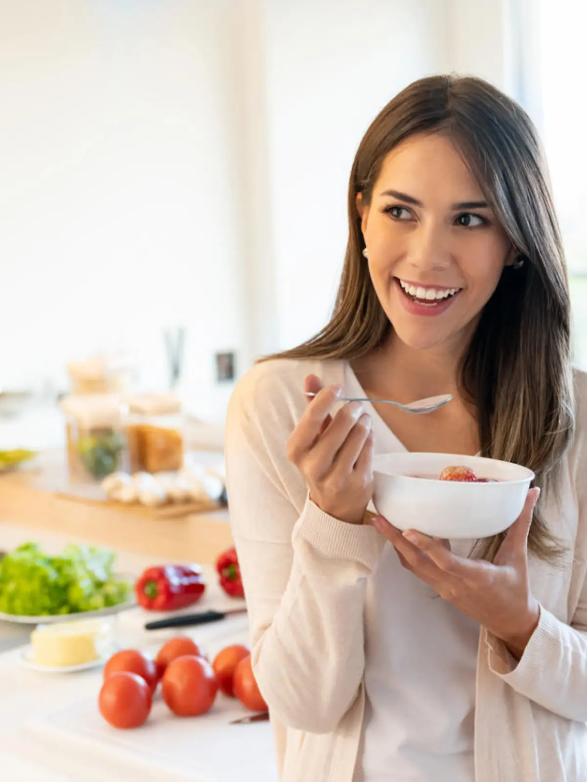 Portrait of a casual woman at home eating a healthy breakfast and looking happy - lifestyle concepts