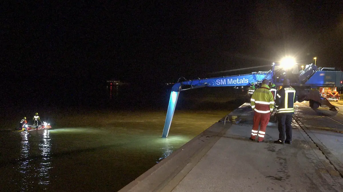 28.02.2022, Nordrhein-Westfalen, Wesel: Einsatzkräfte der Feuerwehr, Wasserschutzpolizei und Polizei suchen im Rhein nach einem Fahrzeug. Nach dem Sturz eines Autos in den Rhein im Landkreis Wesel sind zwei Menschen gerettet worden. Das Fahrzeug sei am Montagabend an der Hafenstraße in den Fluss gefahren, teilte die Polizei mit. Die geretteten Insassen kamen in ein Krankenhaus. Warum das Auto in den Fluss geriet, war zunächst unklar. Foto: Erwin Pottgiesser/dpa +++ dpa-Bildfunk +++
