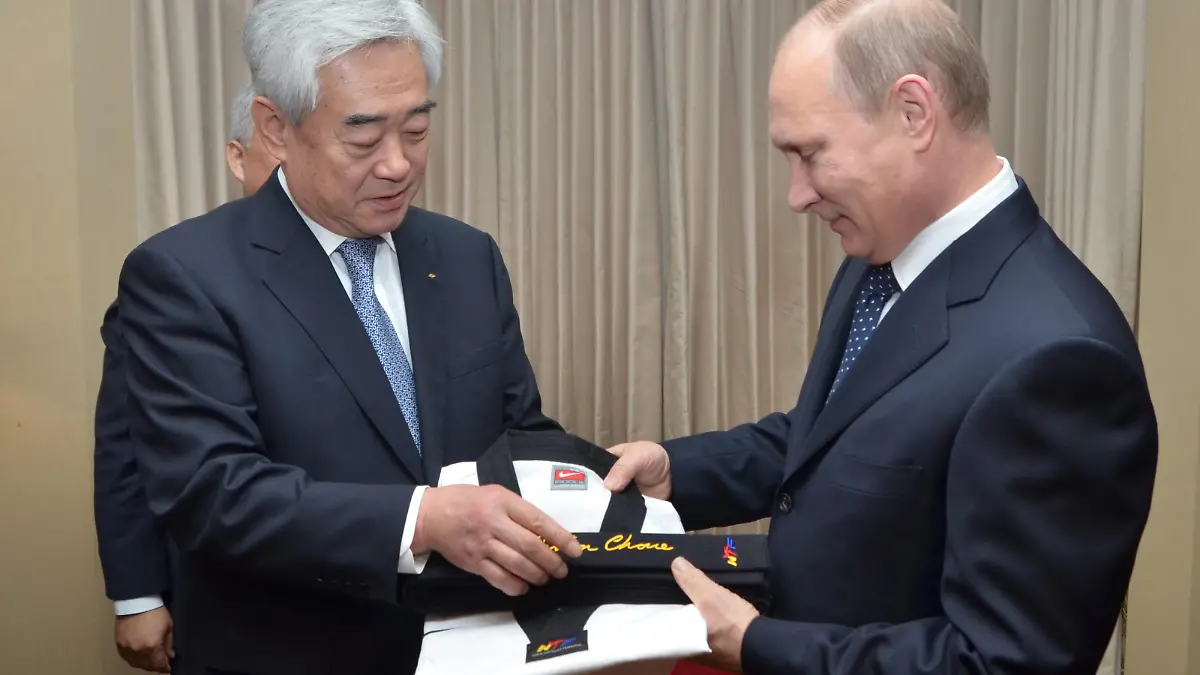 epa03947631 A handout picture made available by the World Taekwondo Federation (WTF), shows Russian President Vladimir Putin (R) receiving an honorary nineth degree black belt and a uniform from Choue Chung-won, president of the Seoul-based WTF, at a hotel in Seoul, South Korea, 13 November 2013. Putin arrived in Seoul earlier in the day for a one-day visit for the second summit talk with South Korean President Park Geun-hye. EPA/WTF SOUTH KOREA OUT HANDOUT EDITORIAL USE ONLY/NO SALES +++ dpa-Bildfunk +++