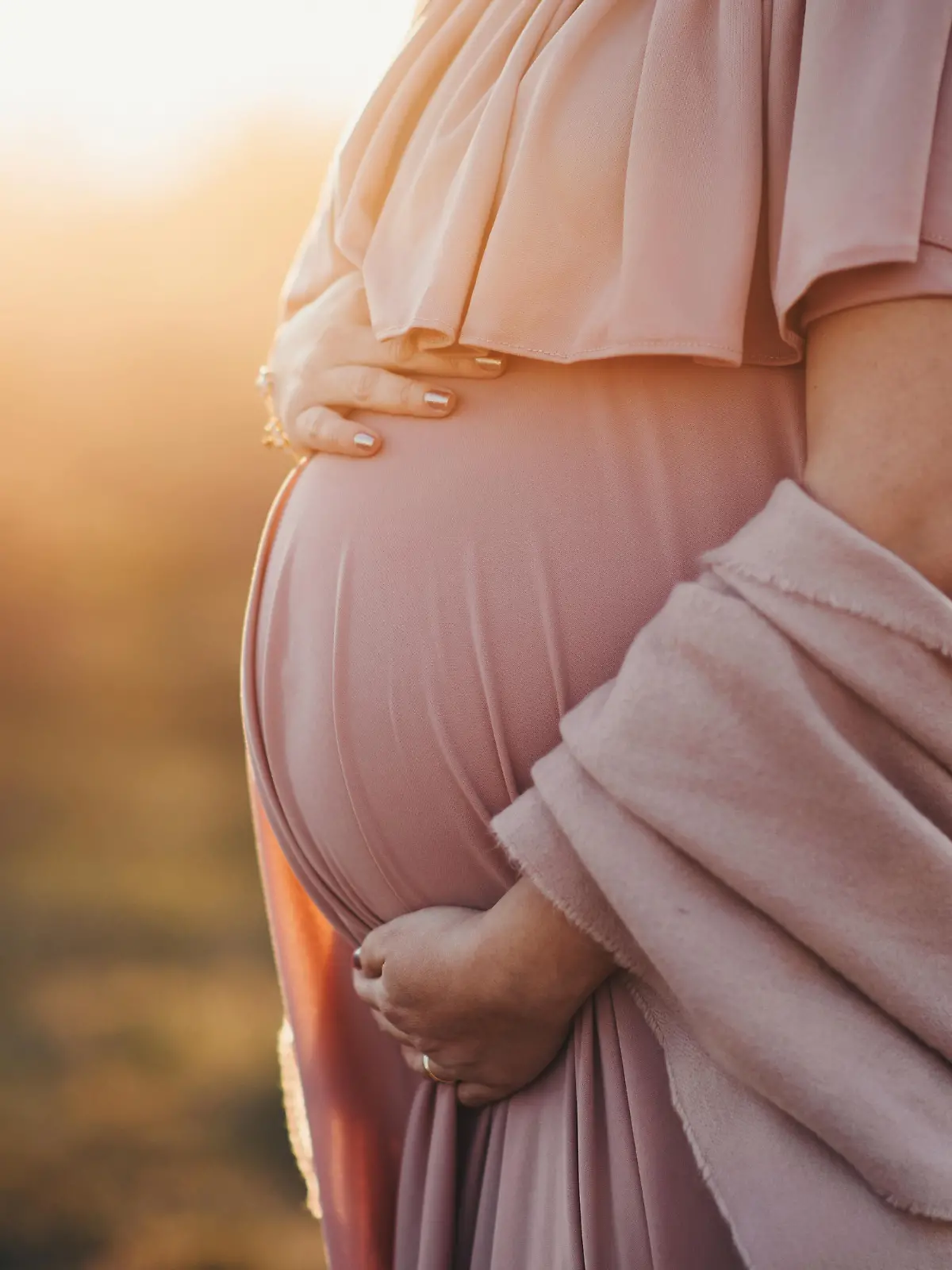 pregnant woman in a dusty pink dress, sunset photoshoot