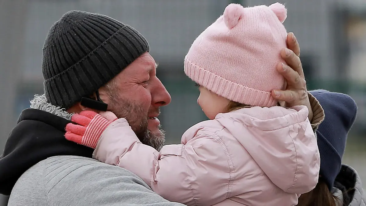 27.02.2022, Polen, Medyka: Ein Vater umarmt seine Tochter, als die Familie nach der Flucht aus Ukraine am Grenzübergang Medyka wieder zusammenkommt. Wegen des russischen Angriffs auf die Ukraine sind nach Angaben des UN-Flüchtlingshilfswerks (UNHCR) etwa 368 000 Menschen auf der Flucht. Foto: Visar Kryeziu/AP/dpa +++ dpa-Bildfunk +++