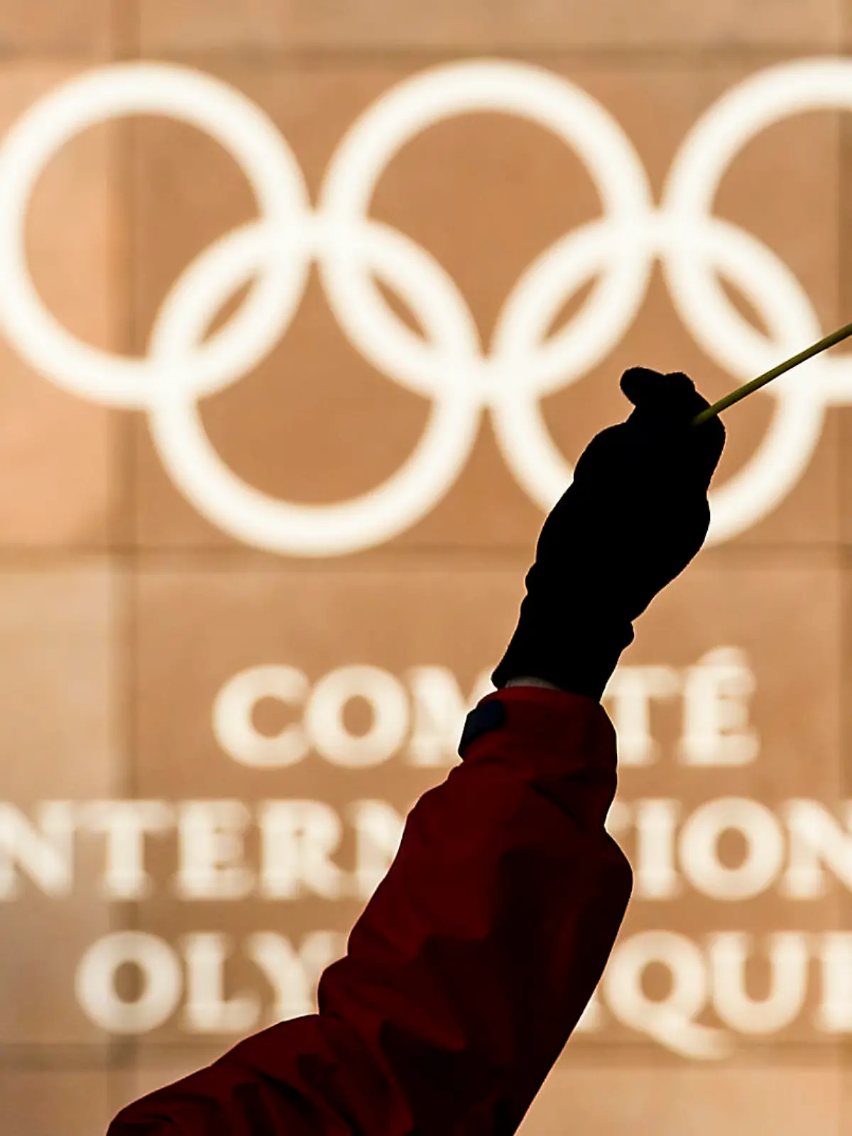 Eine Frau hält am 05.12.2017 eine russische Fahne vor den olympischen Ringen am Hauptquartierdes Internationalen Olympischen Komitees (IOC) in Lausanne (Schweiz). Das IOC wollte im Laufe des Tages über Strafen bis hin zu einem Ausschluss der Sport-Großmacht Russland von den Olympischen Winterspielen im Februar in Südkorea beraten. Möglich ist auch ein Verbot russischer Symbole wie der Fahne und der Hymne Foto: Jean-Christophe Bott/KEYSTONE/dpa +++(c) dpa - Bildfunk+++