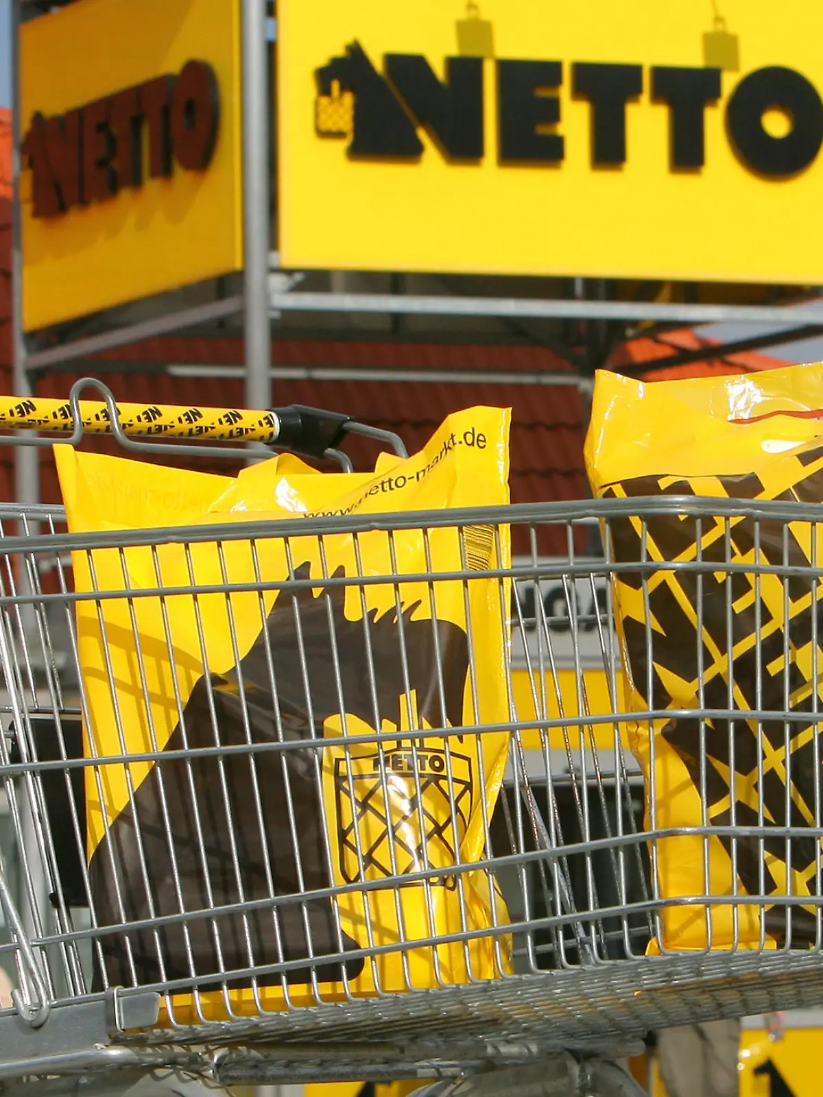 Ein Einkaufswagen mit Einkaufstüten vor einem Verkaufsmarkt der OHG NETTO Supermarkt GmbH & Co. am Dienstag (10.03.2009) in Rostock. Hauptsitz von NETTO Deutschland ist Stavenhagen (Kreis Demmin) in Mecklenburg-Vorpommern. Bundesweit zählt das Unternehmen nach eigenen Angaben mehr als 3.300 Mitarbeiter. Gegründet wurde NETTO Deutschland im Juli 1990 als Tochter des dänischen Unternehmens Dansk Supermarked. Seit 2005 gehört NETTO zu 75 er Dansk Supermarked und zu 25 er Edeka. Das Unternehmen betreibt inzwischen über 280 Märkte in den Berlin, Brandenburg, Mecklenburg-Vorpommern, Sachsen-Anhalt, Sachsen, Niedersachsen, Schleswig-Holstein und dem Großraum Hamburg. Foto: Bernd Wüstneck  +++(c) dpa - Report+++