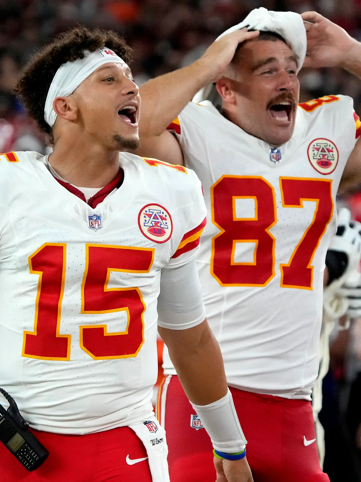Kansas City Chiefs quarterback Patrick Mahomes (15) and tight end Travis Kelce (87) cheer from the sidelines during the first half of an NFL preseason football game against the Arizona Cardinals, Saturday, Aug. 19, 2023, in Glendale, Ariz. (AP Photo/Rick Scuteri)
