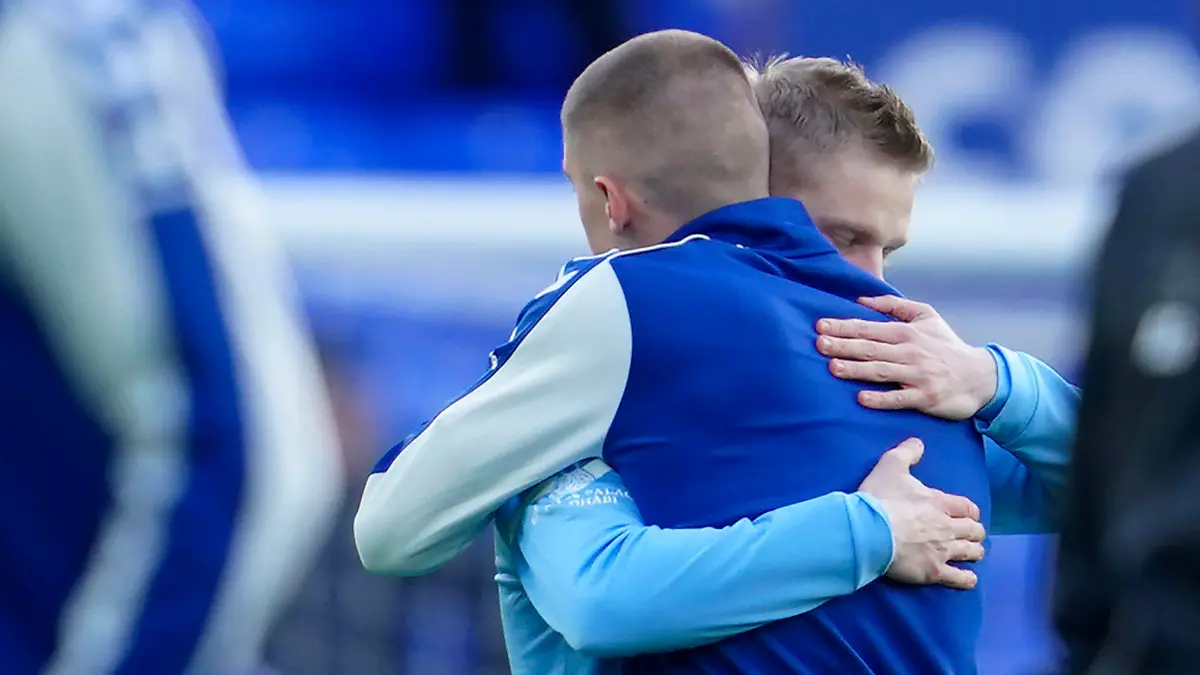 Manchester City's Oleksandr Zinchenko of Ukraine, left, hugs Everton's Vitaliy Mykolenko of Ukraine before the English Premier League soccer match between Everton and Manchester City at Goodison Park in Liverpool, England, Saturday, Feb. 26, 2022. (AP Photo/Jon Super)