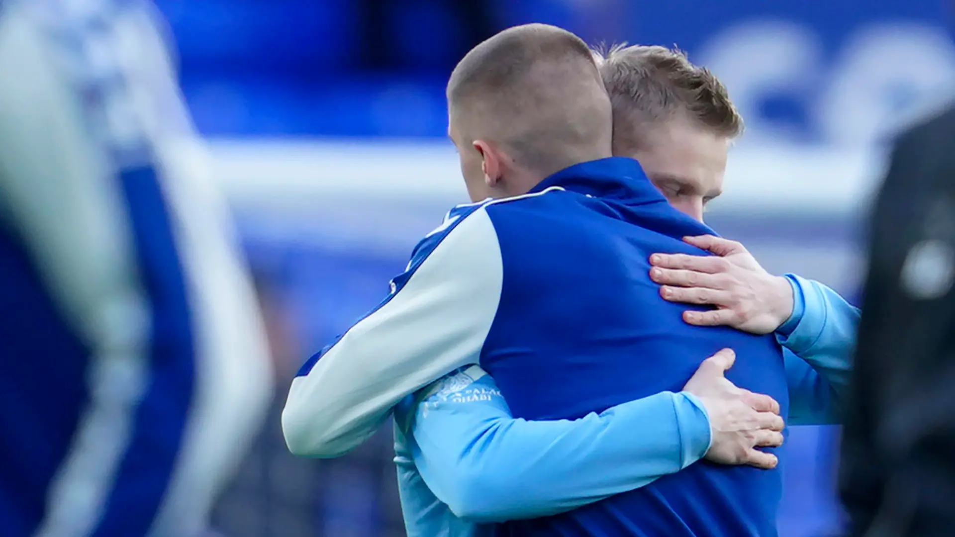 Manchester City's Oleksandr Zinchenko of Ukraine, left, hugs Everton's Vitaliy Mykolenko of Ukraine before the English Premier League soccer match between Everton and Manchester City at Goodison Park in Liverpool, England, Saturday, Feb. 26, 2022. (AP Photo/Jon Super)