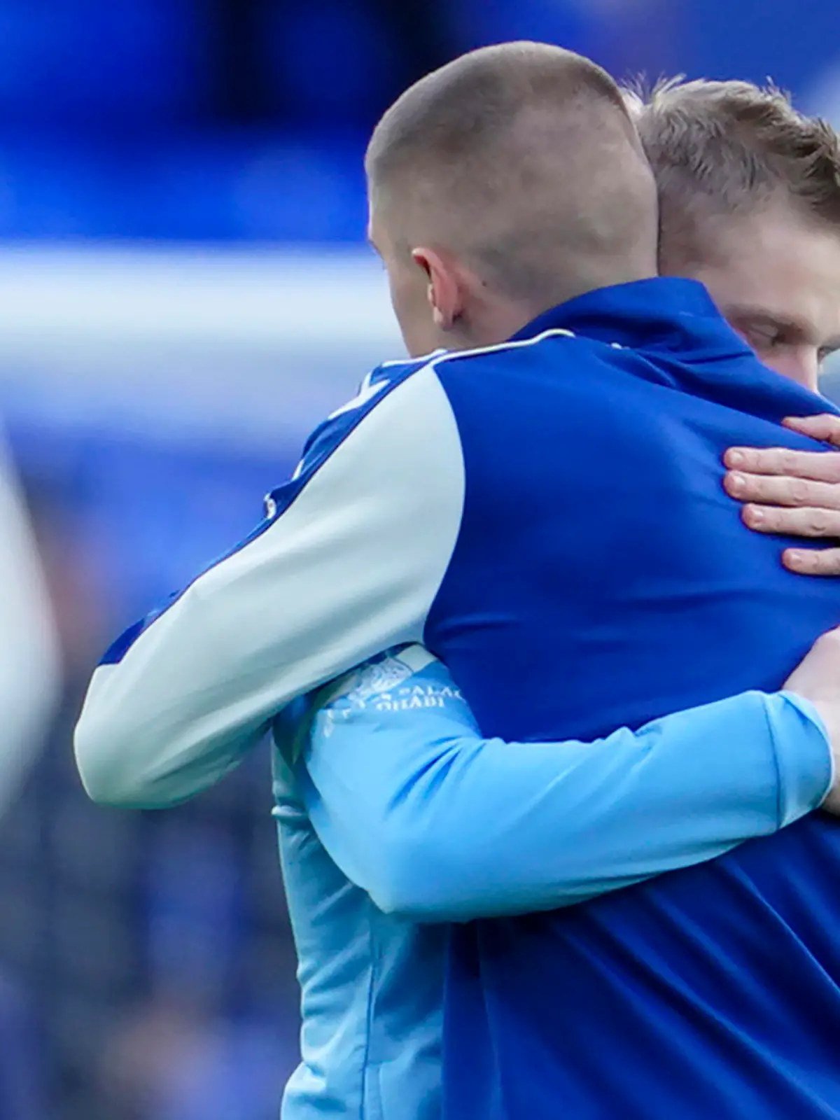Manchester City's Oleksandr Zinchenko of Ukraine, left, hugs Everton's Vitaliy Mykolenko of Ukraine before the English Premier League soccer match between Everton and Manchester City at Goodison Park in Liverpool, England, Saturday, Feb. 26, 2022. (AP Photo/Jon Super)