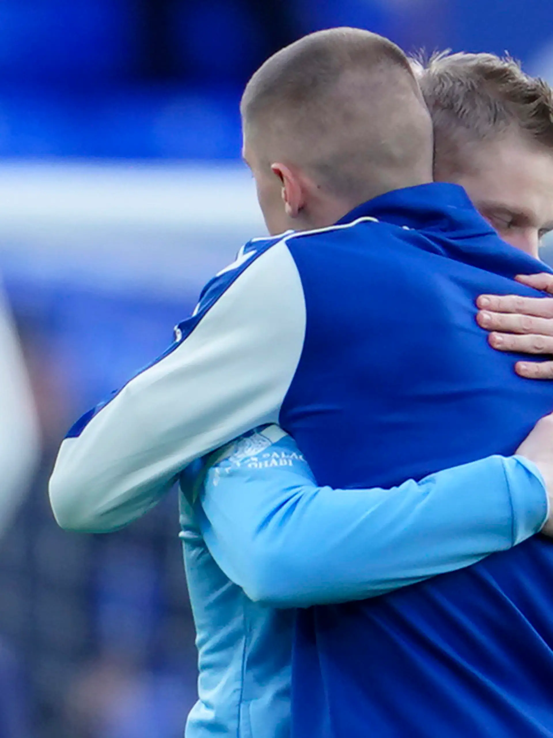 Manchester City's Oleksandr Zinchenko of Ukraine, left, hugs Everton's Vitaliy Mykolenko of Ukraine before the English Premier League soccer match between Everton and Manchester City at Goodison Park in Liverpool, England, Saturday, Feb. 26, 2022. (AP Photo/Jon Super)