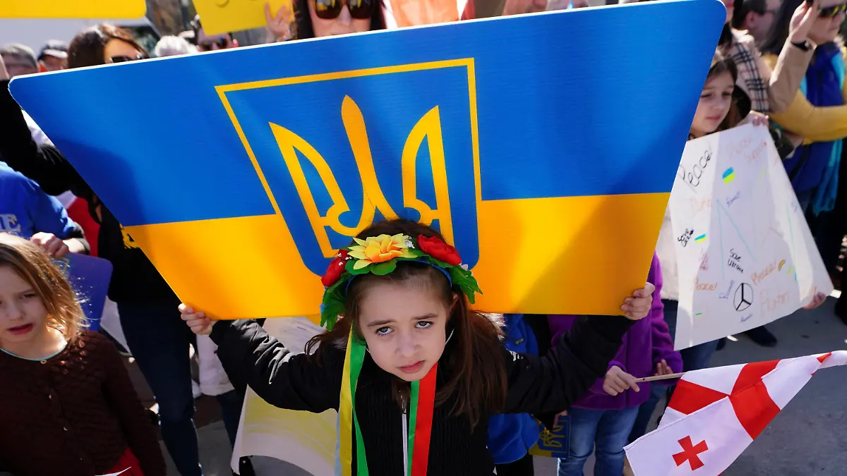 Six-year-old Grace Mokiienko holds sign during a rally to show support for Ukraine Saturday, Feb. 26, 2022, in Atlanta. Grace's father is a Ukrainian immigrant and still has family in Ukraine. Ukrainians in the United States are praying for friends and family, donating money and supplies, and registering outrage. They're pleading for the world to do more as Russia launches a full-scale invasion of its neighbor.  (AP Photo/John Bazemore)