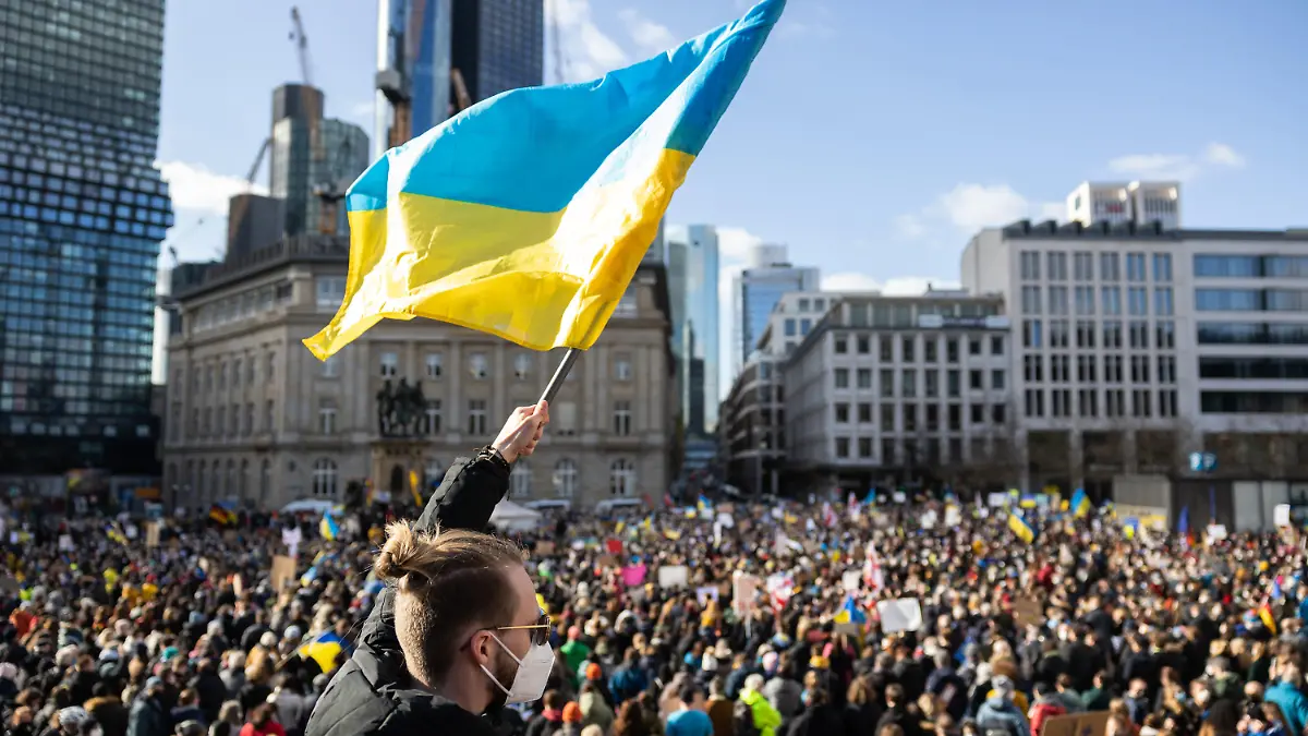 26.02.2022, Hessen, Frankfurt/Main: Ein Demonstrant schwenkt auf der Veranstaltung «Solidarität mit der Ukraine - Frieden in Osteuropa» von Bündnis 90/Die Grünen am Rathenauplatz eine ukrainische Flagge. Foto: Hannes P. Albert/dpa +++ dpa-Bildfunk +++