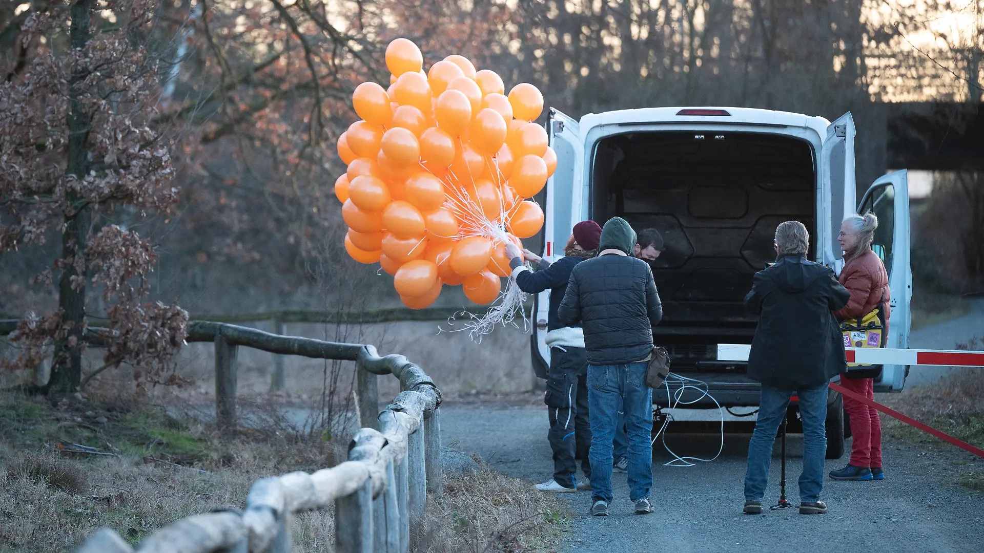 25.02.2022, Hessen, Kelsterbach: Klimaaktivisten der Aktion "Aufstand der letzten Generation" stehen mit Luftballons am Flughafen Frankfurt. Geplant war mit den Luftballons den Wagen zu verlassen und direkt an den Flughafen zu gehen. Die Polizei stoppte die Aktion noch am Transporter. Foto: Sebastian Gollnow/dpa +++ dpa-Bildfunk +++