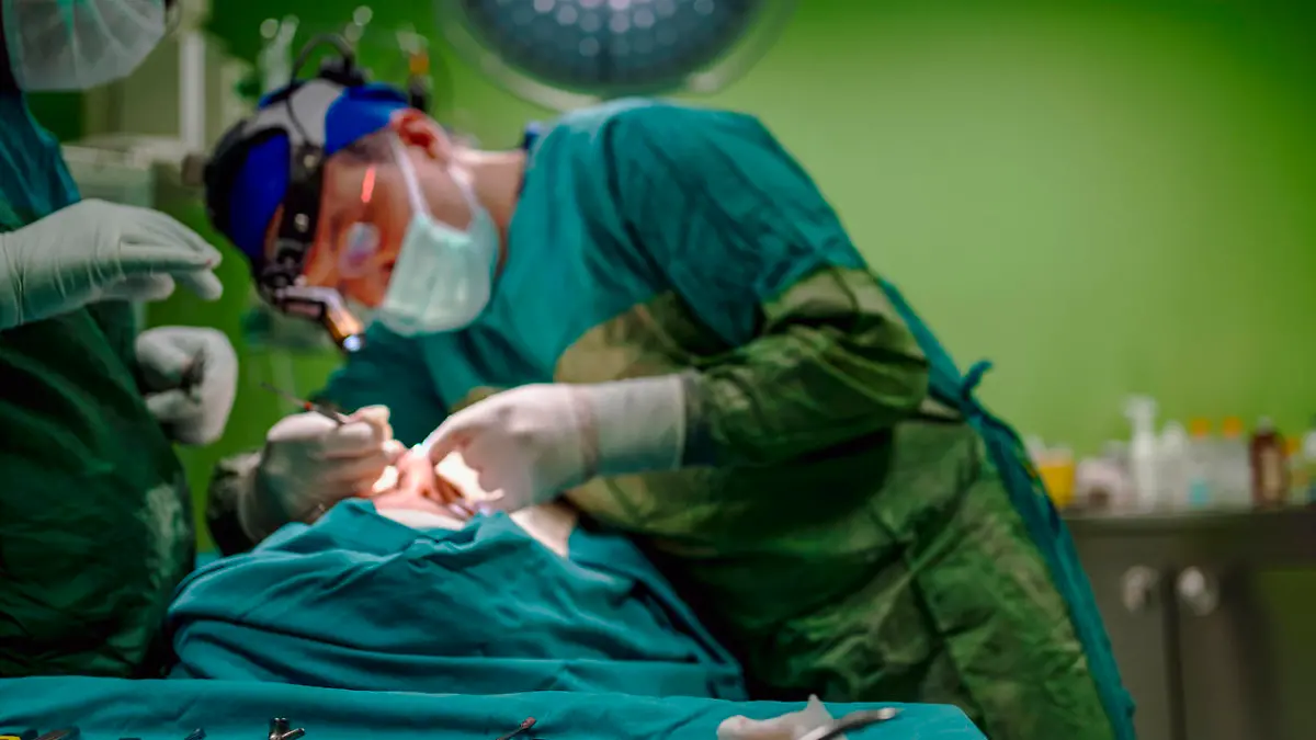 Young male plastic surgeon operates in the operating room of a medical center