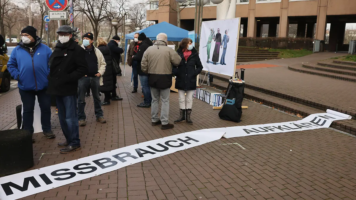 18.01.2022, Nordrhein-Westfalen, Köln: Demonstranten stehen anlässlich des Missbrauchsprozesses vor dem Landgericht hinter einem Banner mit der Aufschrift "Missbrauch aufklären". Heße, Erzbischof von Hamburg ist als Zeuge vor Gericht geladen. In einem Missbrauchsprozess ist ein Priester wegen Kindesmissbrauchs angeklagt. Heße war mit dem Fall befasst. Foto: Oliver Berg/dpa +++ dpa-Bildfunk +++