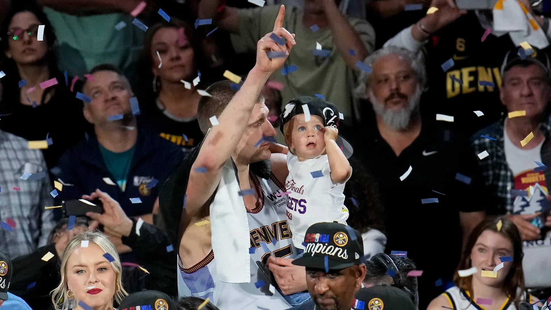 Denver Nuggets center Nikola Jokic, center, celebrates with his daughter after the team won the NBA Championship with a victory over the Miami Heat in Game 5 of basketball's NBA Finals, Monday, June 12, 2023, in Denver. (AP Photo/David Zalubowski)