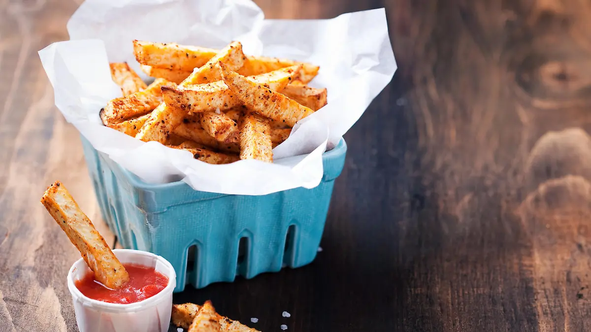 Roasted vegetables (potato and celery root) in ceramic basket and tomato sauce, selective focus
