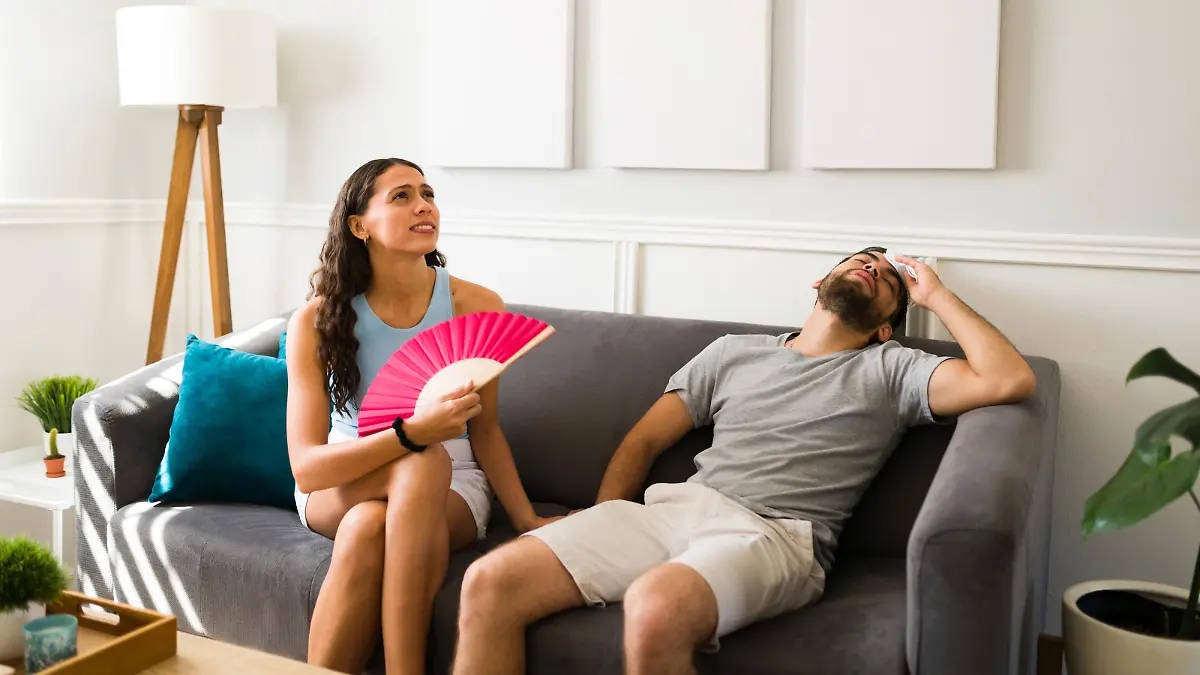 Sweaty young couple without a fan or air conditioning suffering because of the hot weather