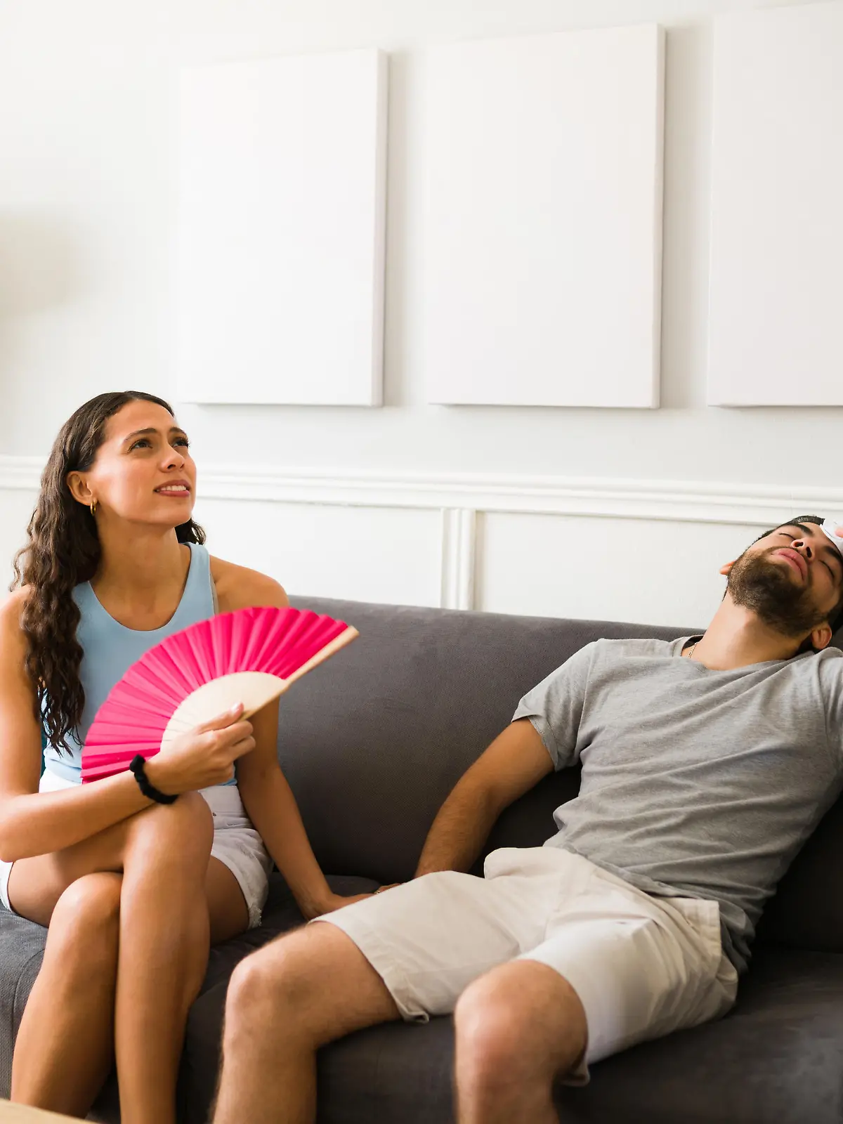 Sweaty young couple without a fan or air conditioning suffering because of the hot weather