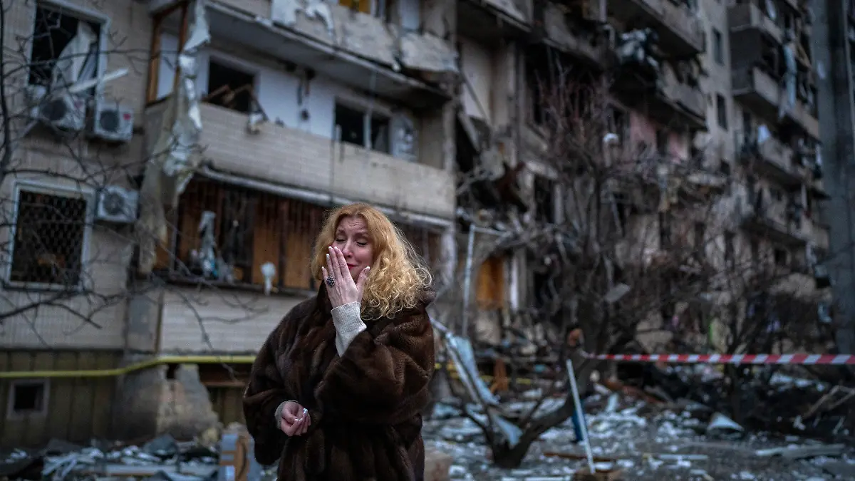 dpatopbilder - 25.02.2022, Ukraine, Kiew: Natali Sewriukowa reagiert neben einem Haus, das bei einem Raketenangriff zerstört wurde. Russische Truppen haben am Donnerstag, 24.02.2022, den erwarteten Angriff auf die Ukraine gestartet. Foto: Emilio Morenatti/AP/dpa +++ dpa-Bildfunk +++