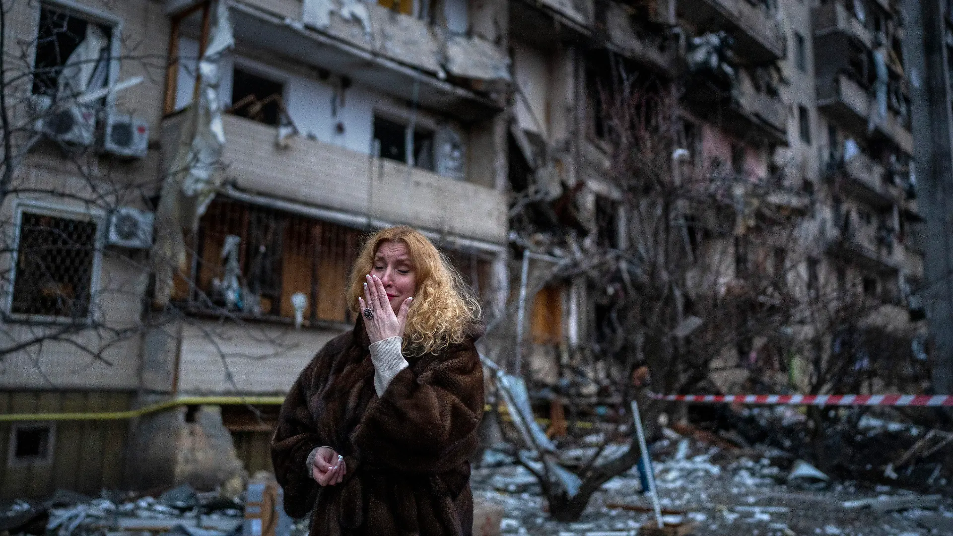 dpatopbilder - 25.02.2022, Ukraine, Kiew: Natali Sewriukowa reagiert neben einem Haus, das bei einem Raketenangriff zerstört wurde. Russische Truppen haben am Donnerstag, 24.02.2022, den erwarteten Angriff auf die Ukraine gestartet. Foto: Emilio Morenatti/AP/dpa +++ dpa-Bildfunk +++