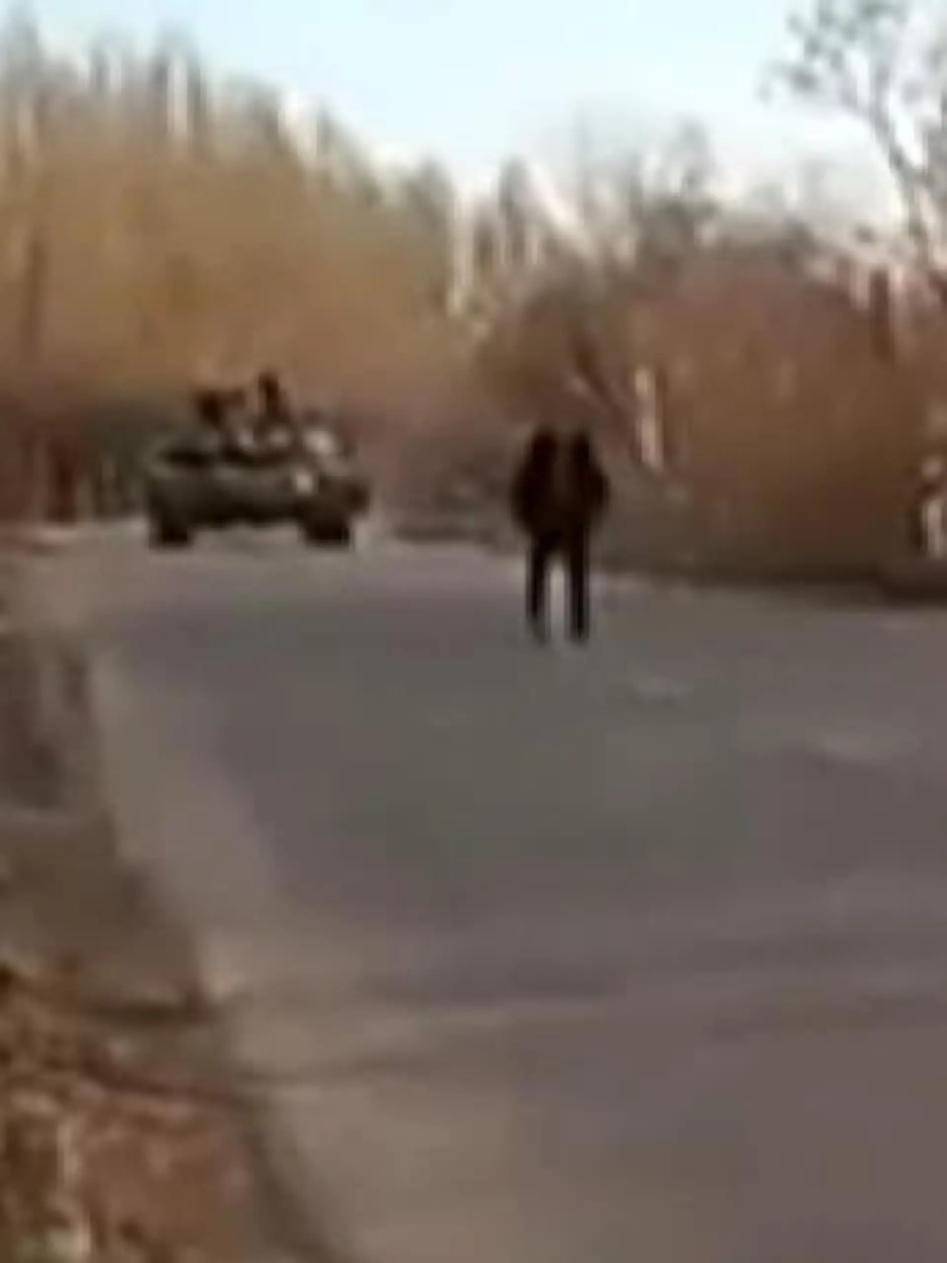 Eine Gruppe ukrainischer Männer blockiert eine Dorfstraße, als ein Panzer anrückt. Dieser dreht daraufhin um. Jubel  bei den Männern auf der Straße - zwar nur ein kleiner Erfolg in den letzten Tagen, aber einer mit Symbolkraft.