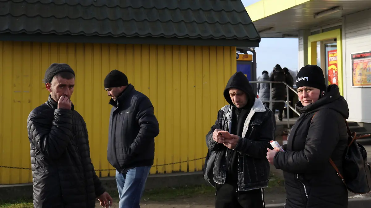 People stand outside a shop at the border crossing between Poland and Ukraine, after Russian President Vladimir Putin authorized a military operation in eastern Ukraine, in Medyka, Poland, February 24, 2022. REUTERS/Kacper Pempel