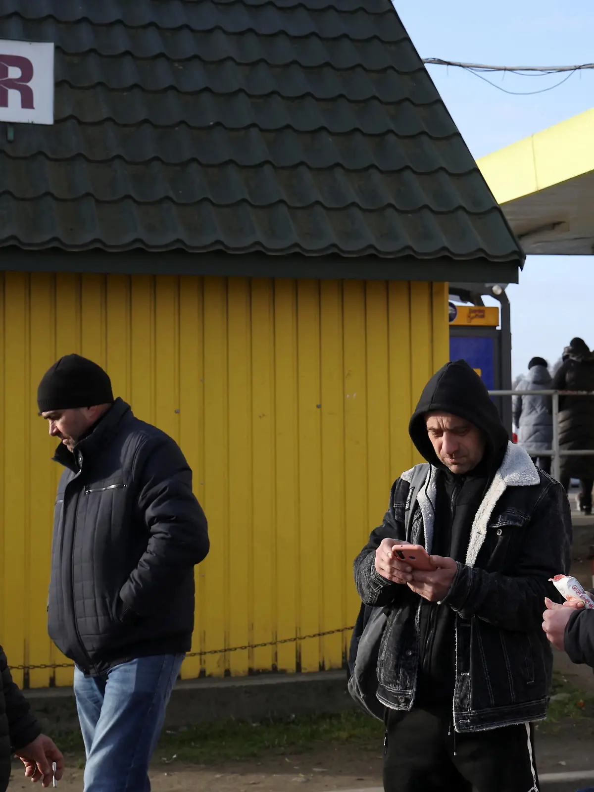 People stand outside a shop at the border crossing between Poland and Ukraine, after Russian President Vladimir Putin authorized a military operation in eastern Ukraine, in Medyka, Poland, February 24, 2022. REUTERS/Kacper Pempel