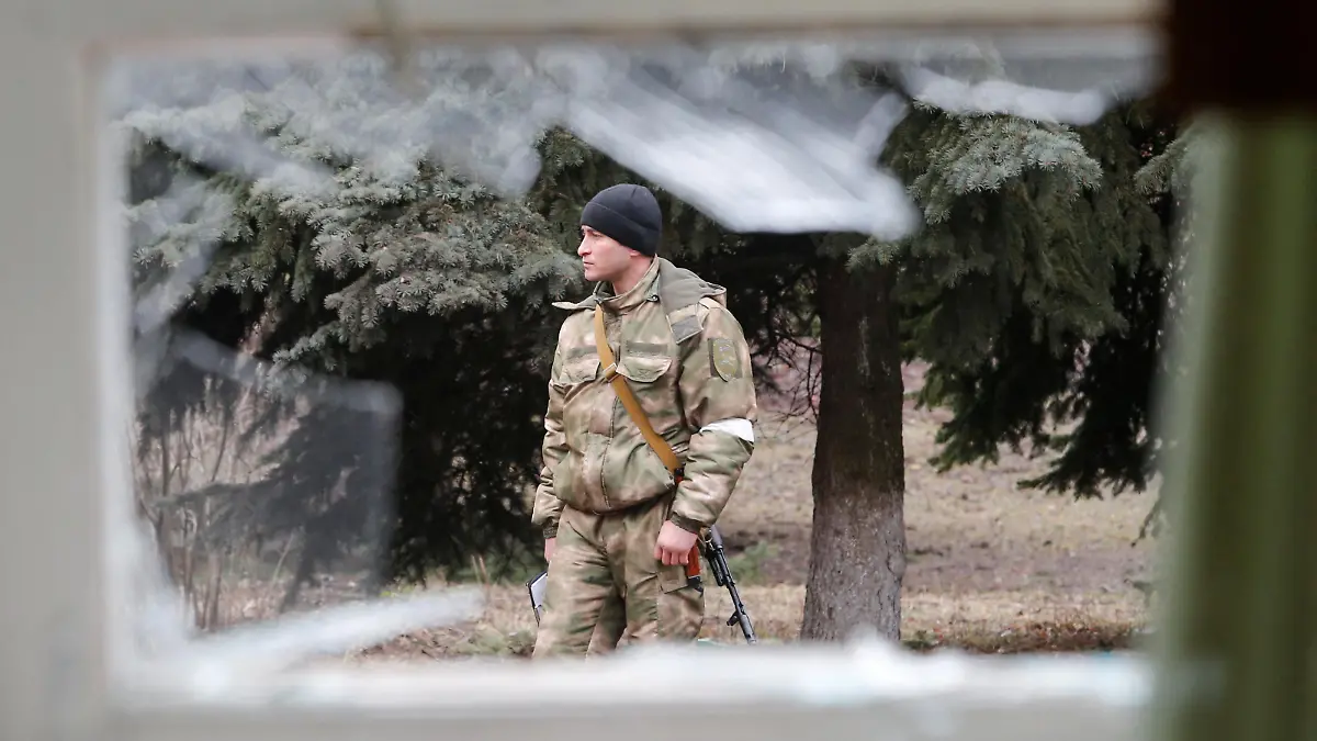 A militant is seen outside a school building, which locals said was damaged by recent shelling, in the separatist-controlled town of Horlivka (Gorlovka) in the Donetsk region, Ukraine February 25, 2022. REUTERS/Alexander Ermochenko